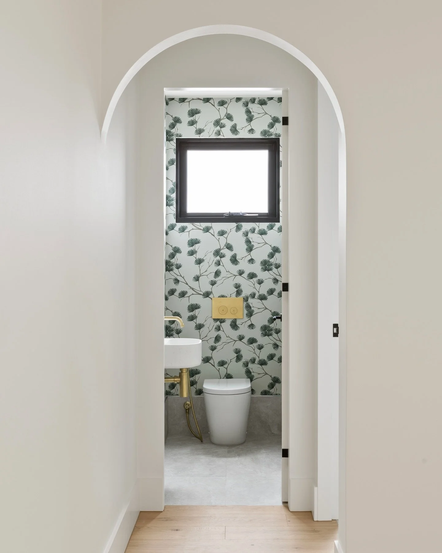 A perfect little powder room ✨

It features walls enveloped in this beautiful wallpaper and brushed brass tapware that provide that little pop of brightness. 

The arched walls really makes it feel as though you&rsquo;re stepping into a different wor