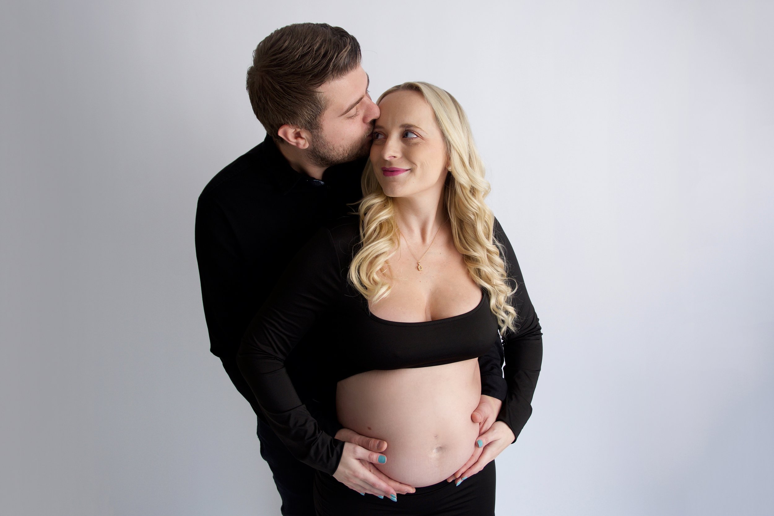 Man kissing pregant lady on the head