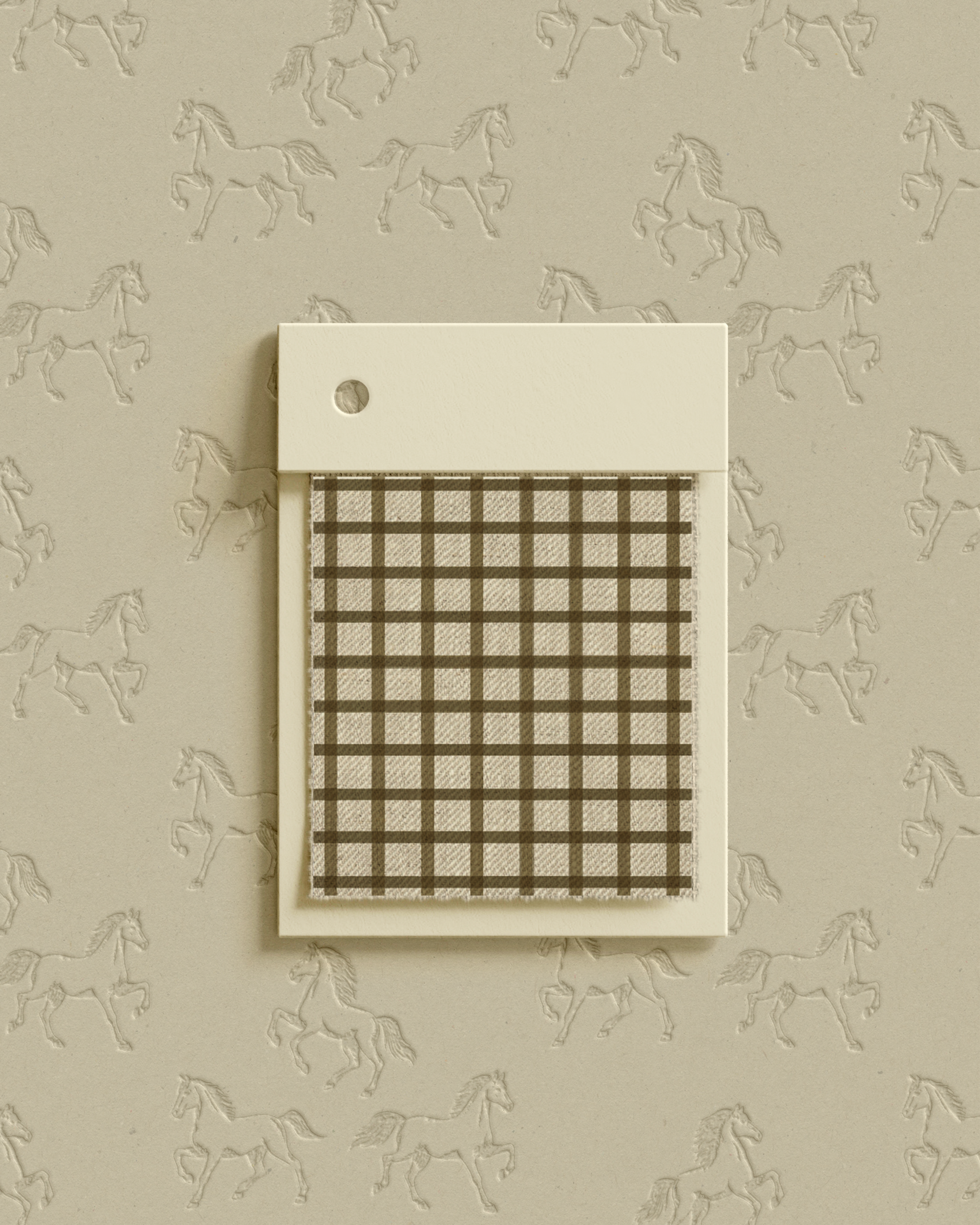 A sample card with a checkered brown and white fabric swatch, mounted on a cream plastic card with a circular hole, placed against a wallpaper with a repeating horse pattern.