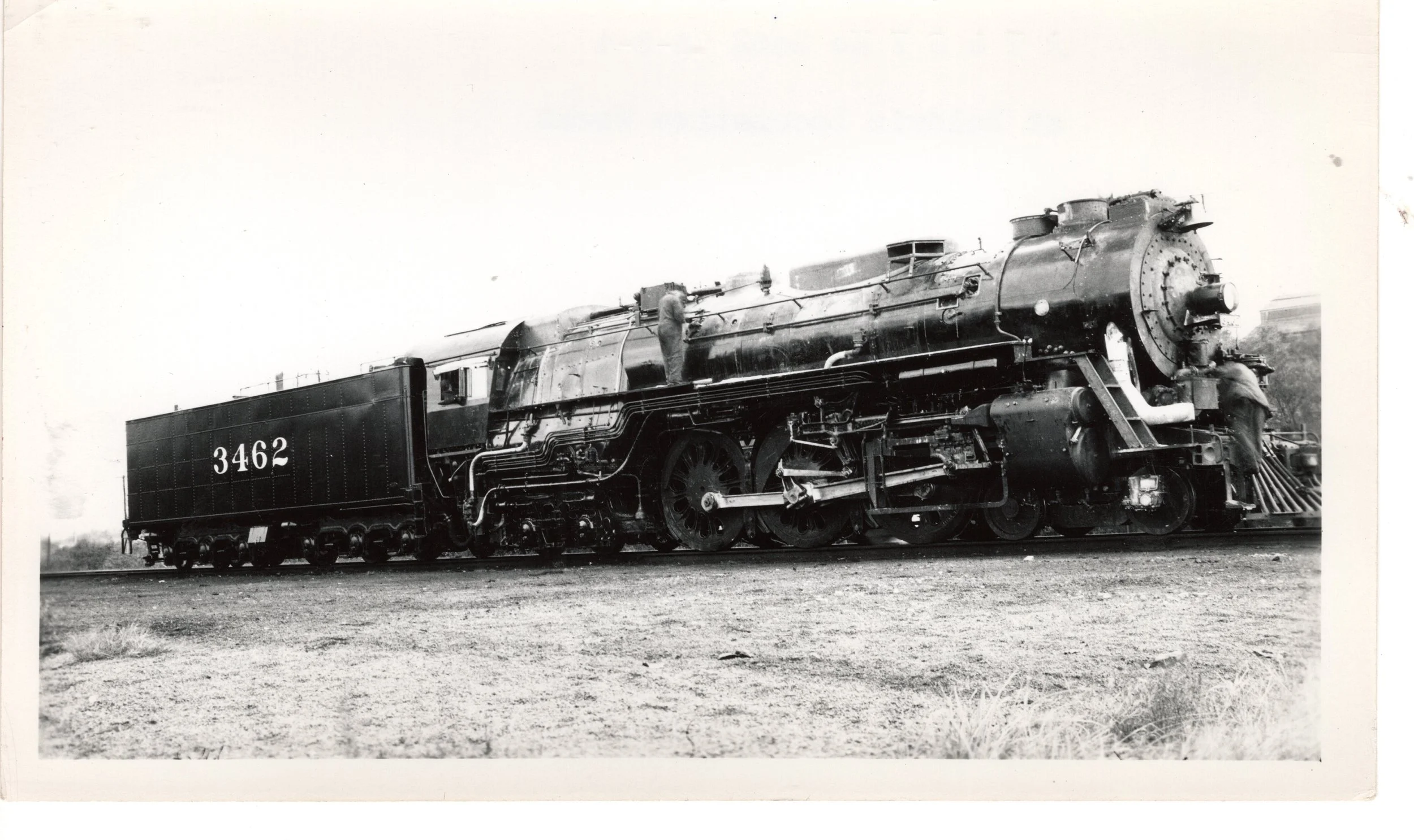 Atchison Topeka & Santa Fe 3462 4-6-4 at the Baldwin Locomotive Works.  Two employees are attending to details on the locomotive.