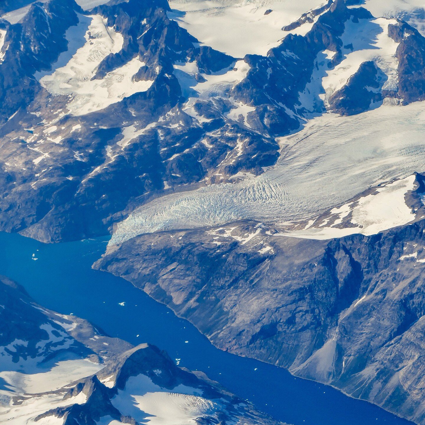 Glacier calving into fjord, East Greenland, seen out the window when returning from Iceland