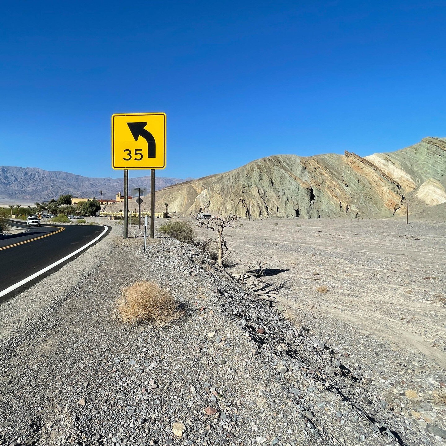 Furnace Creek Wash in March 2022 before the August floods. The huge wash makes a hard left turn before spreading out onto the alluvial fan. Drivers are cautioned to slow when making the same turn, but floodwaters don't read signs. The parking lot on 