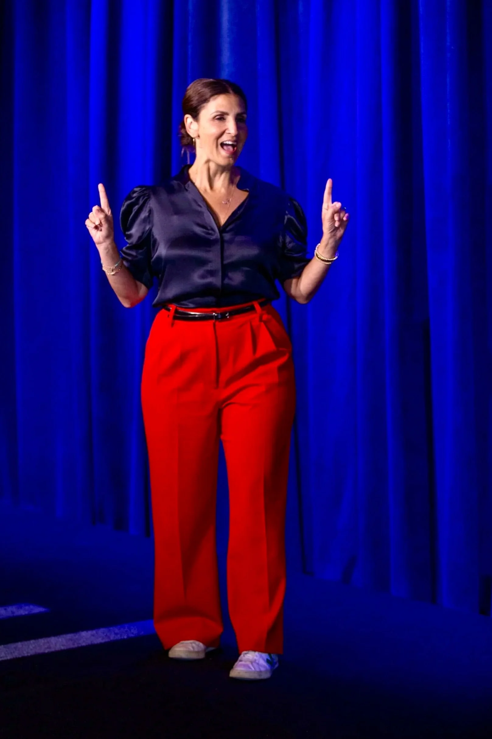 Michelle Pollack stands on stage giving a keynote speech on leadership