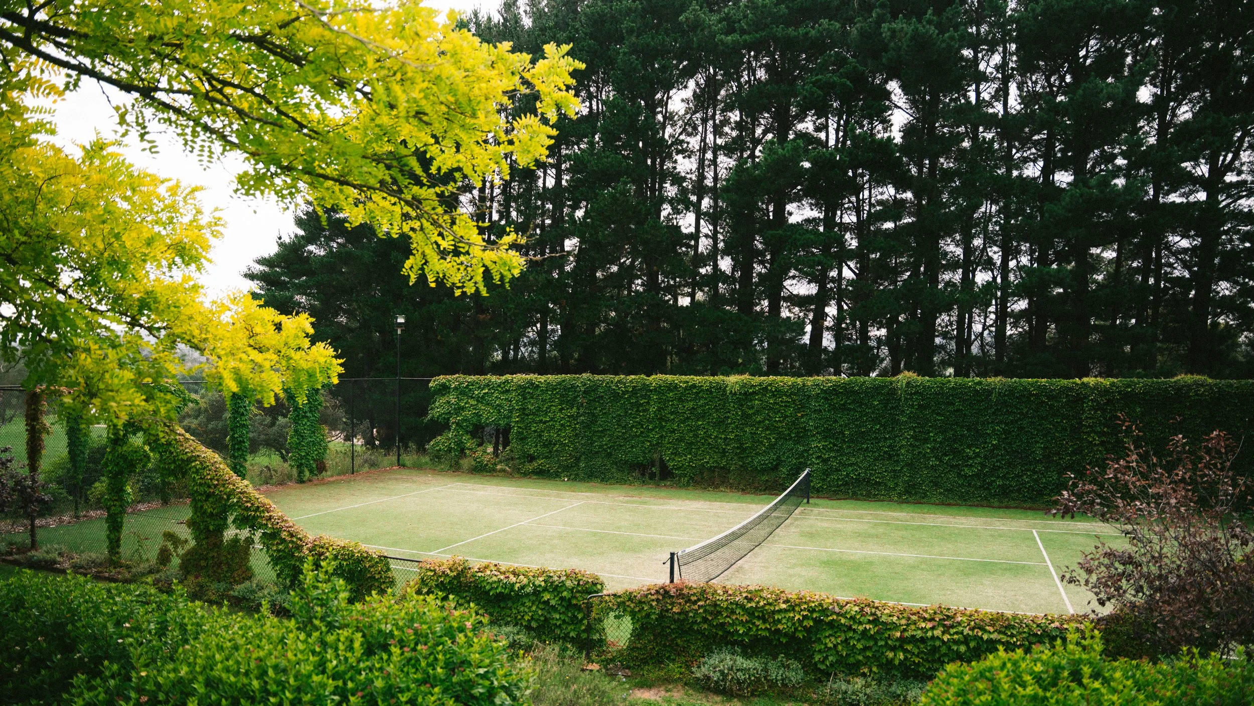 Hedged tennis court in autumn at a luxury farm stay in NSW — Waldara Estate, Edith NSW, near Sydney and the Blue Mountains