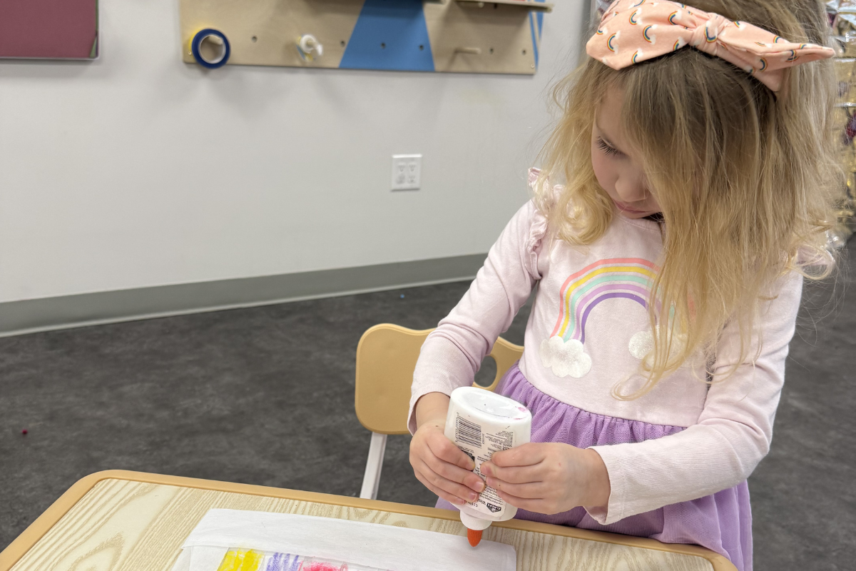 Child practicing fine motor skills activity using glue in ABA therapy session