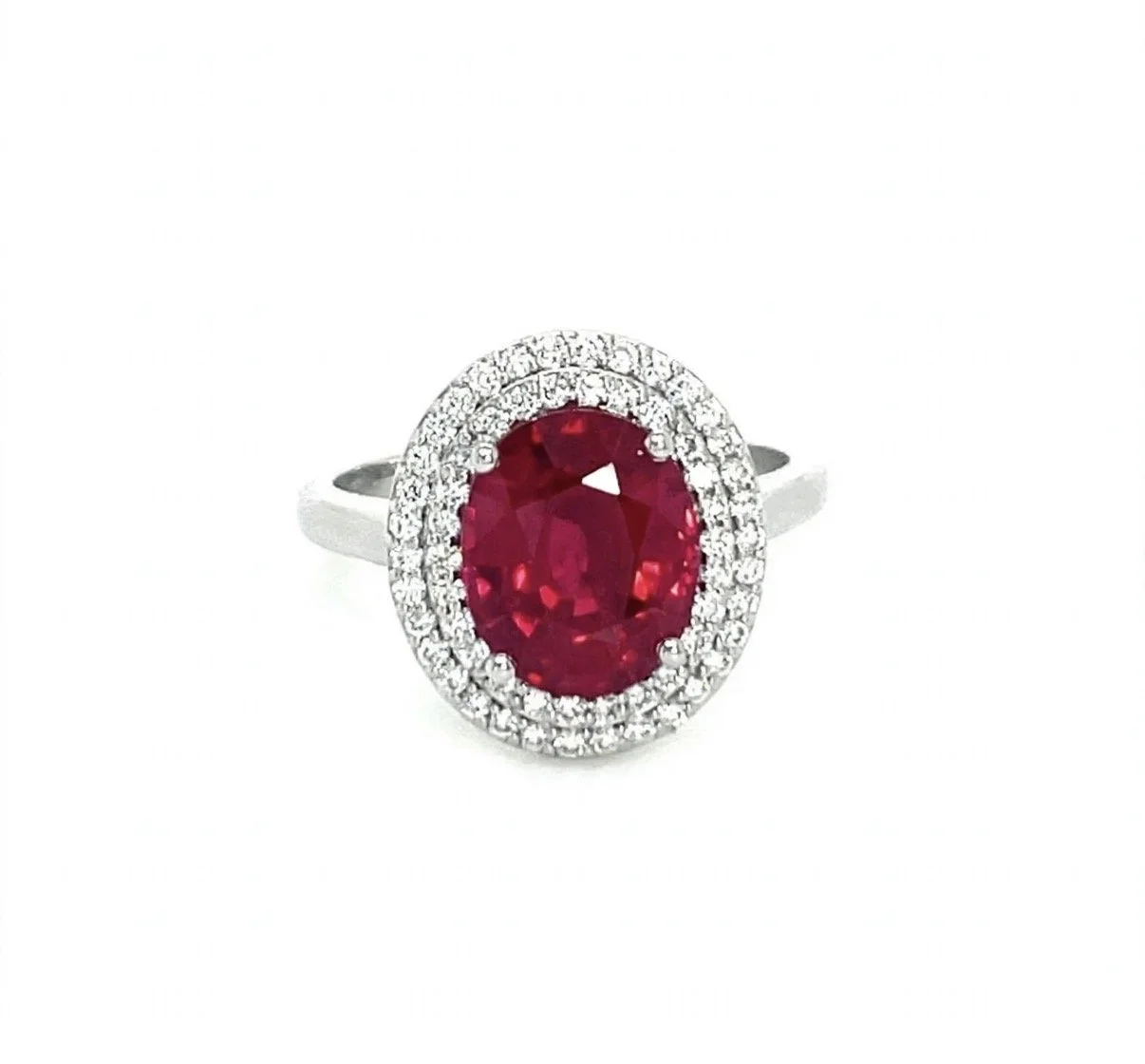White gold ring with an oval ruby gemstone surrounded by a double halo of small diamonds.