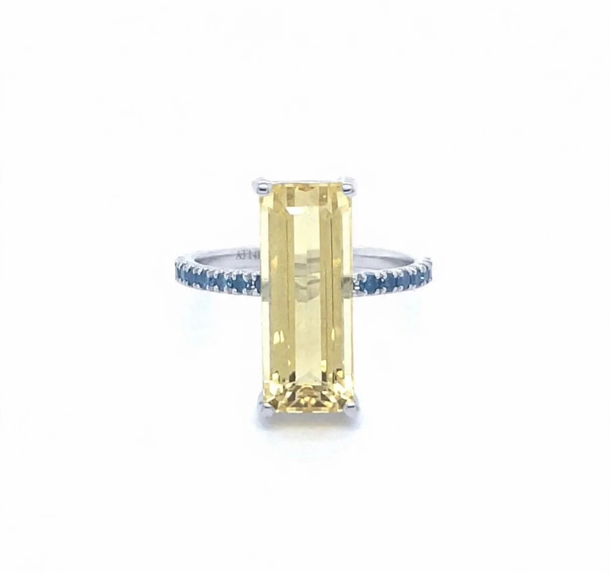 White gold ring with a rectangular garnet gemstone and blue diamond accents on the band.