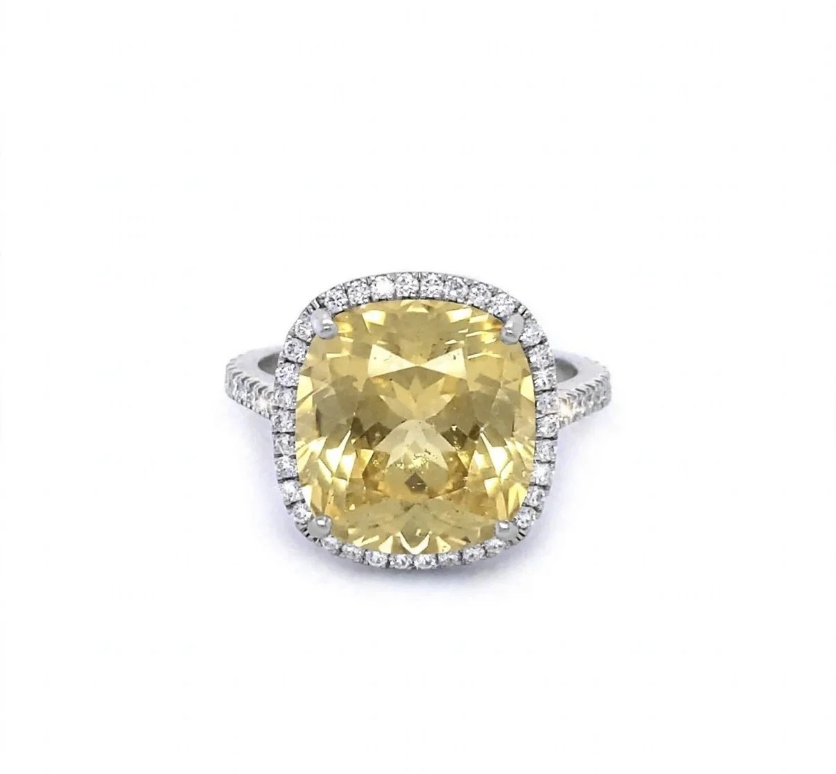 White gold ring with a large, cushion-cut yellow garnet gemstone surrounded by small diamonds.