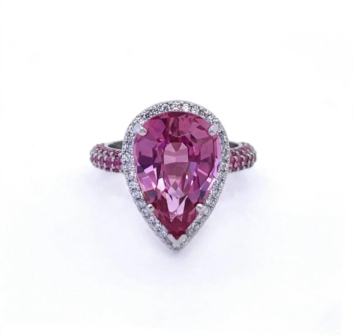Ring with a large, pear-shaped pink sapphire gemstone surrounded by smaller clear stones on a white gold band.