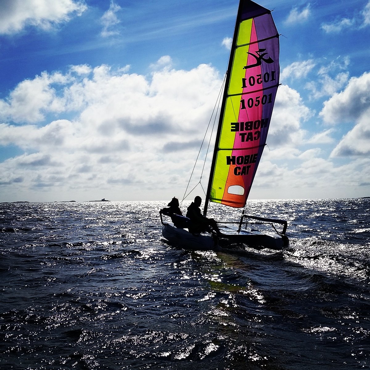 Hobie cat som seiler på havet i sola