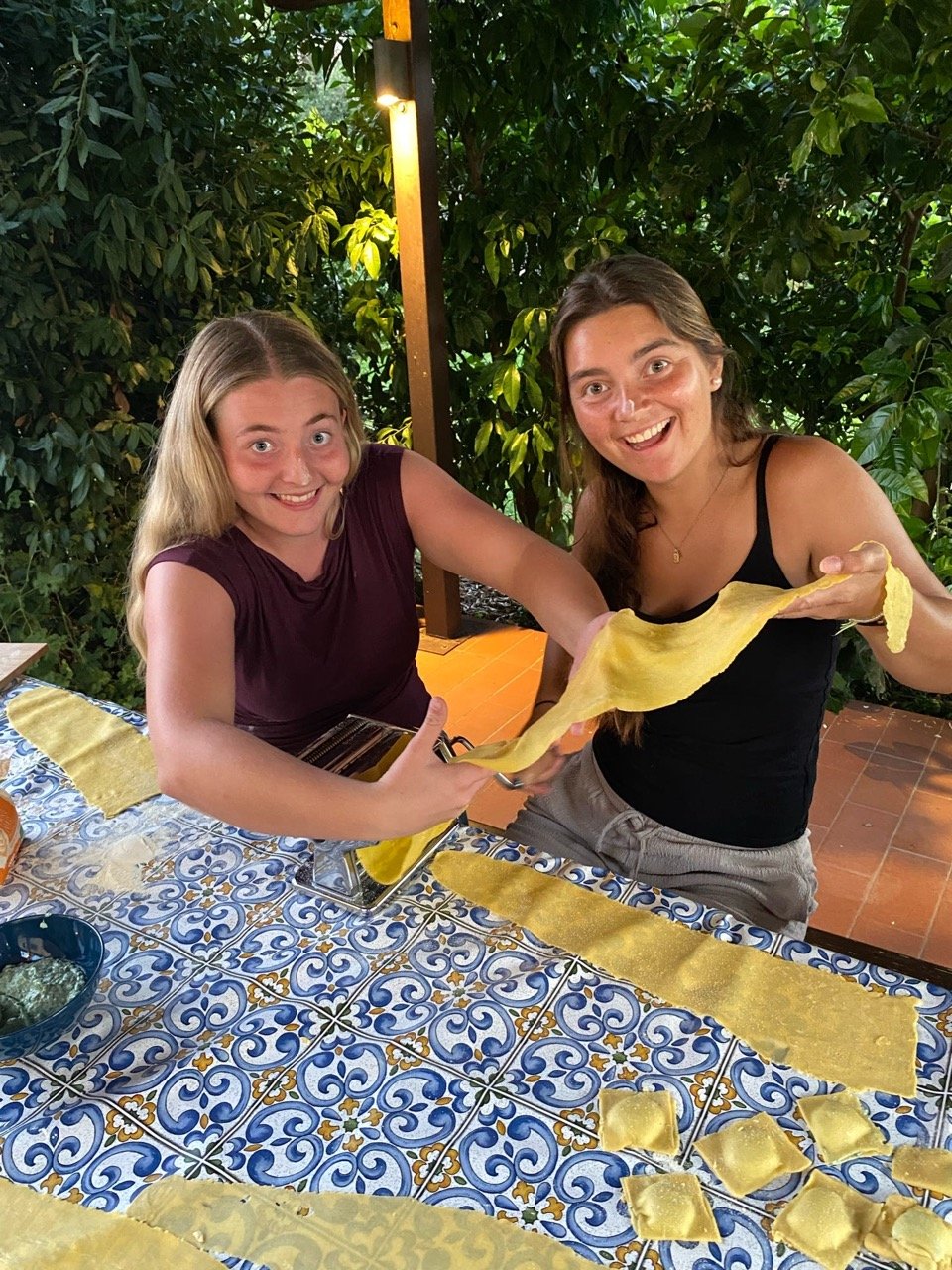 to smilende elever som lager hjemmelaget pasta