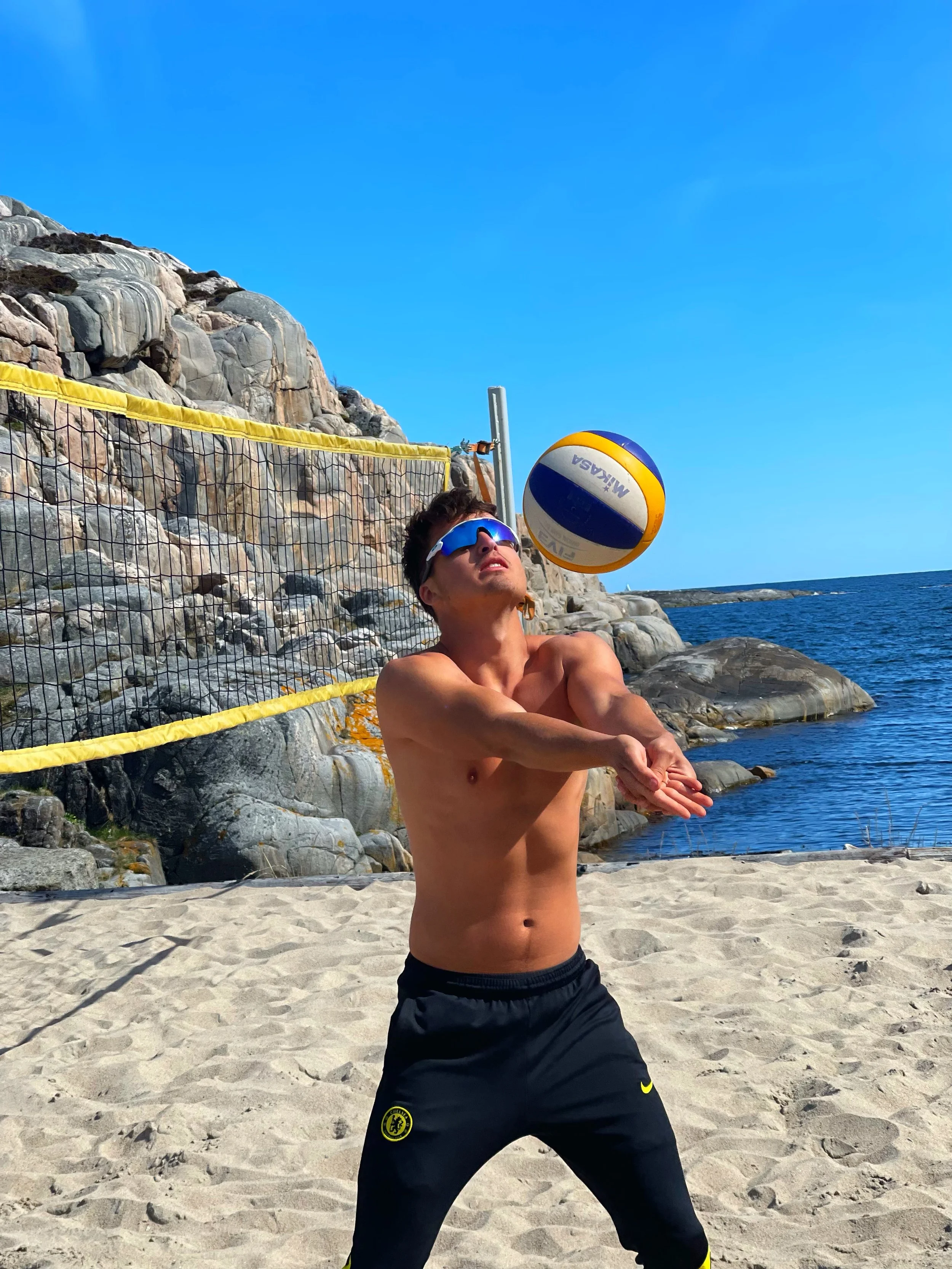 Gutt spiller beachvolley ved skjærgården