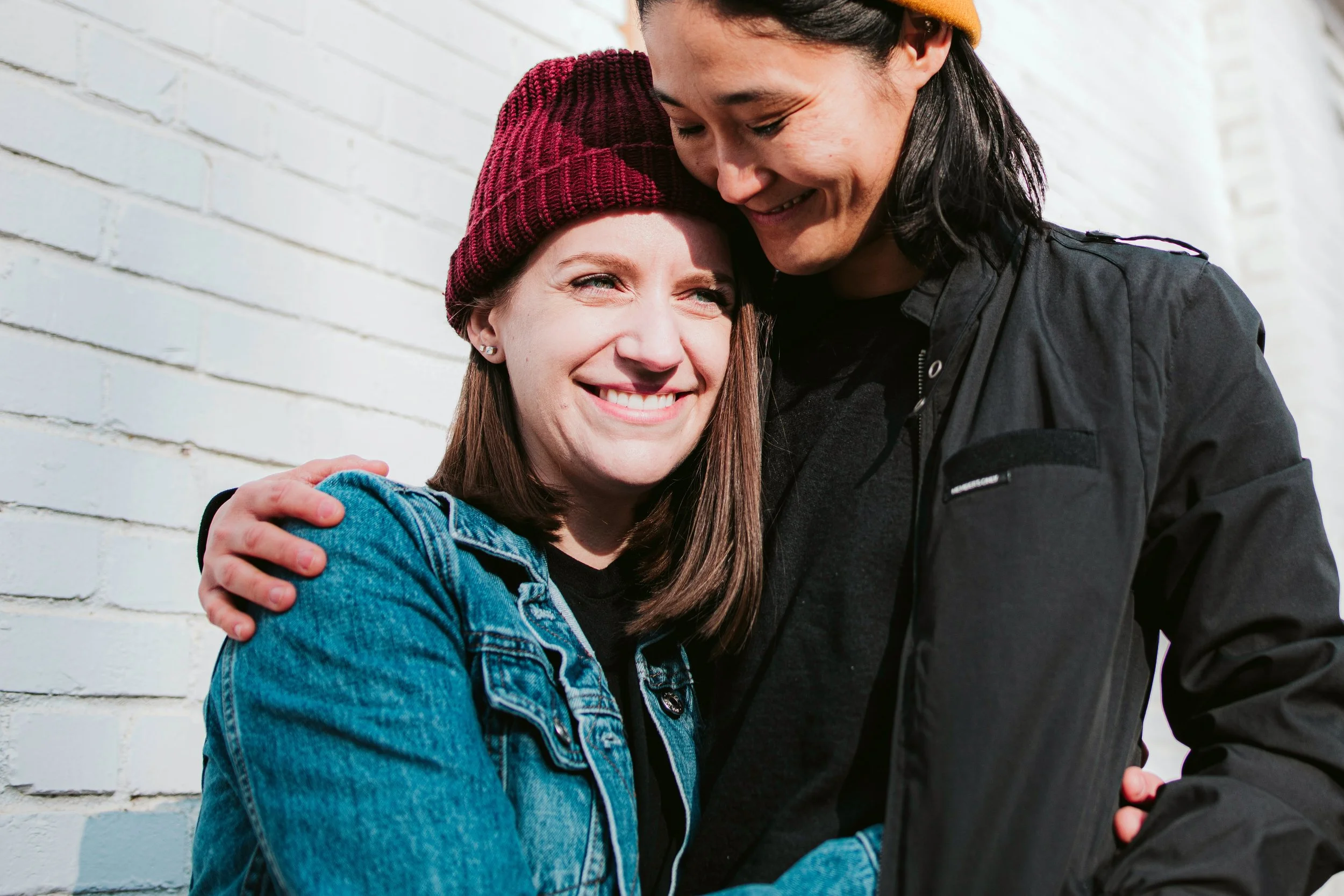 Photo of a female couple smiling with their arms around one another. See what Gottman Method couples counseling can do to improve your relationship. Get started with Gottman couples counseling in Indianapolis, IN