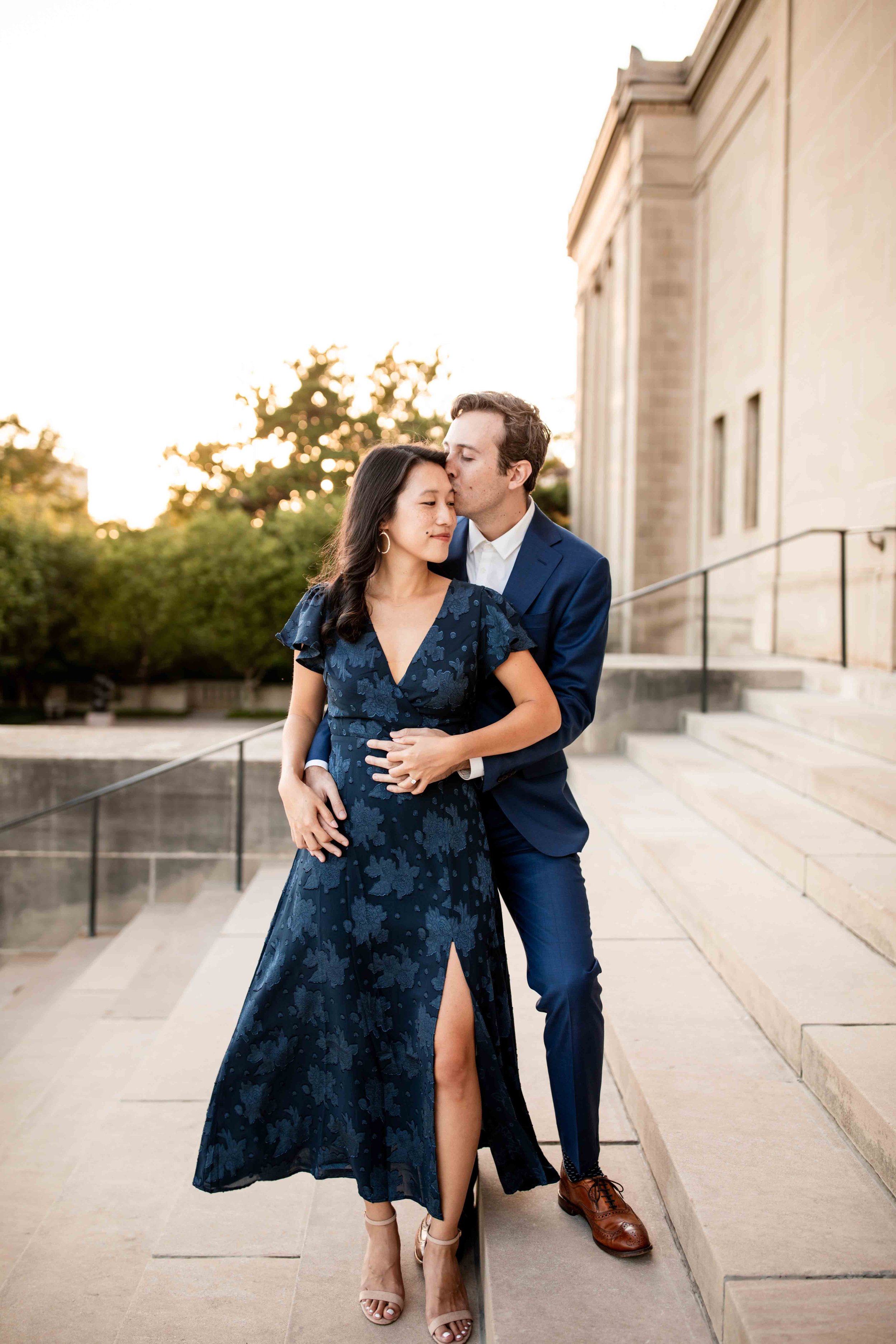 Engaged couple on the stairs of Nelson Atkins Museum of Art in Kansas City