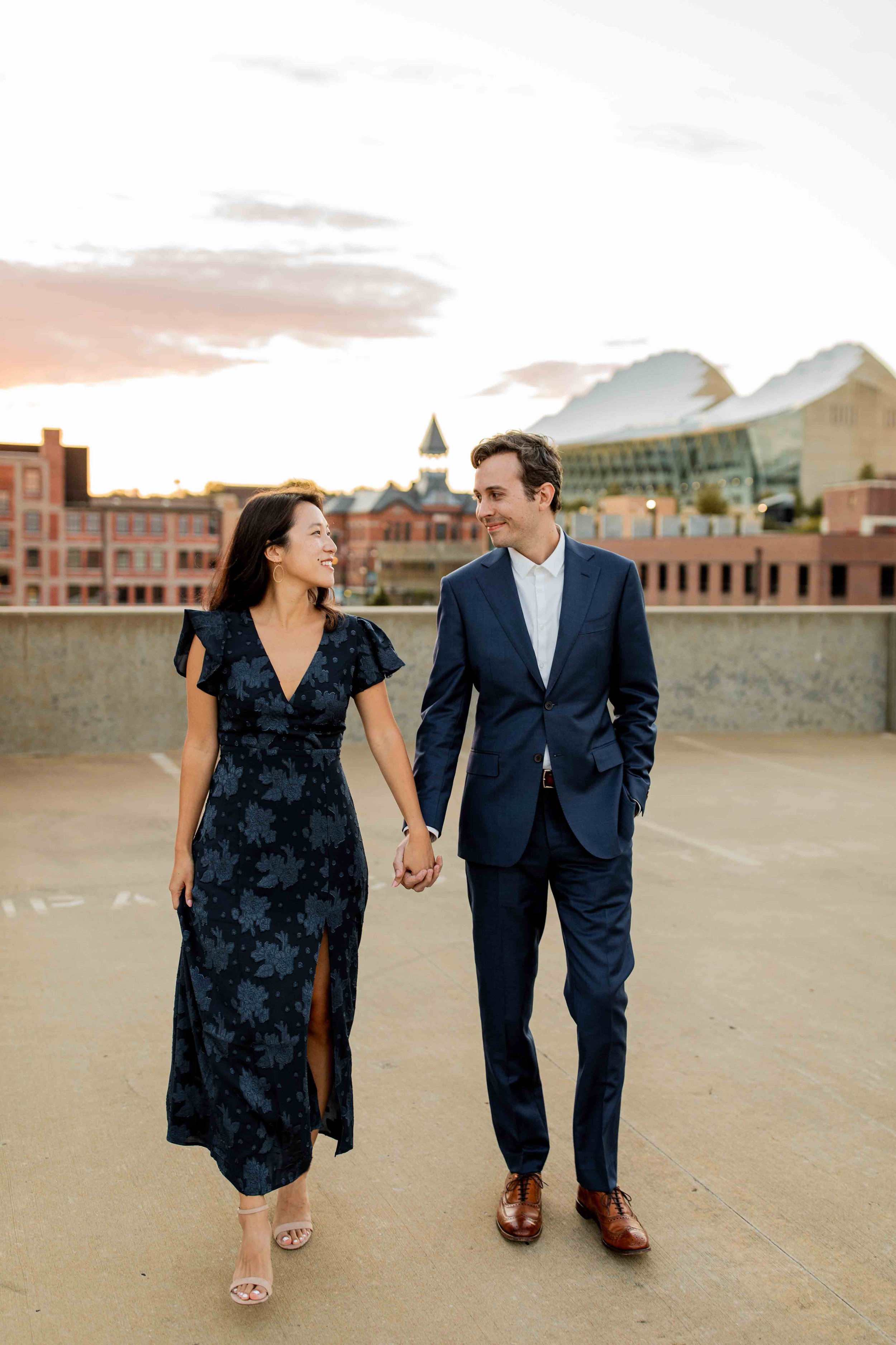 Couple holding hands walking at Library Memorial with Kauffman Center in the background