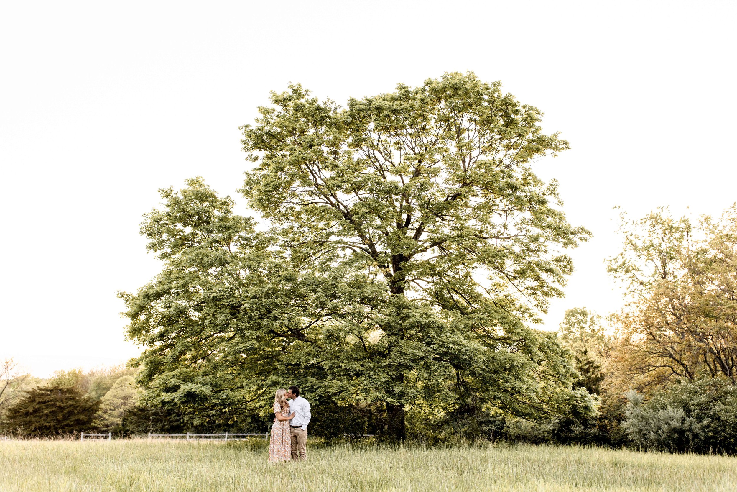 Couple kissing under a tree at Longview Mansion in Lee's Summit Missouri
