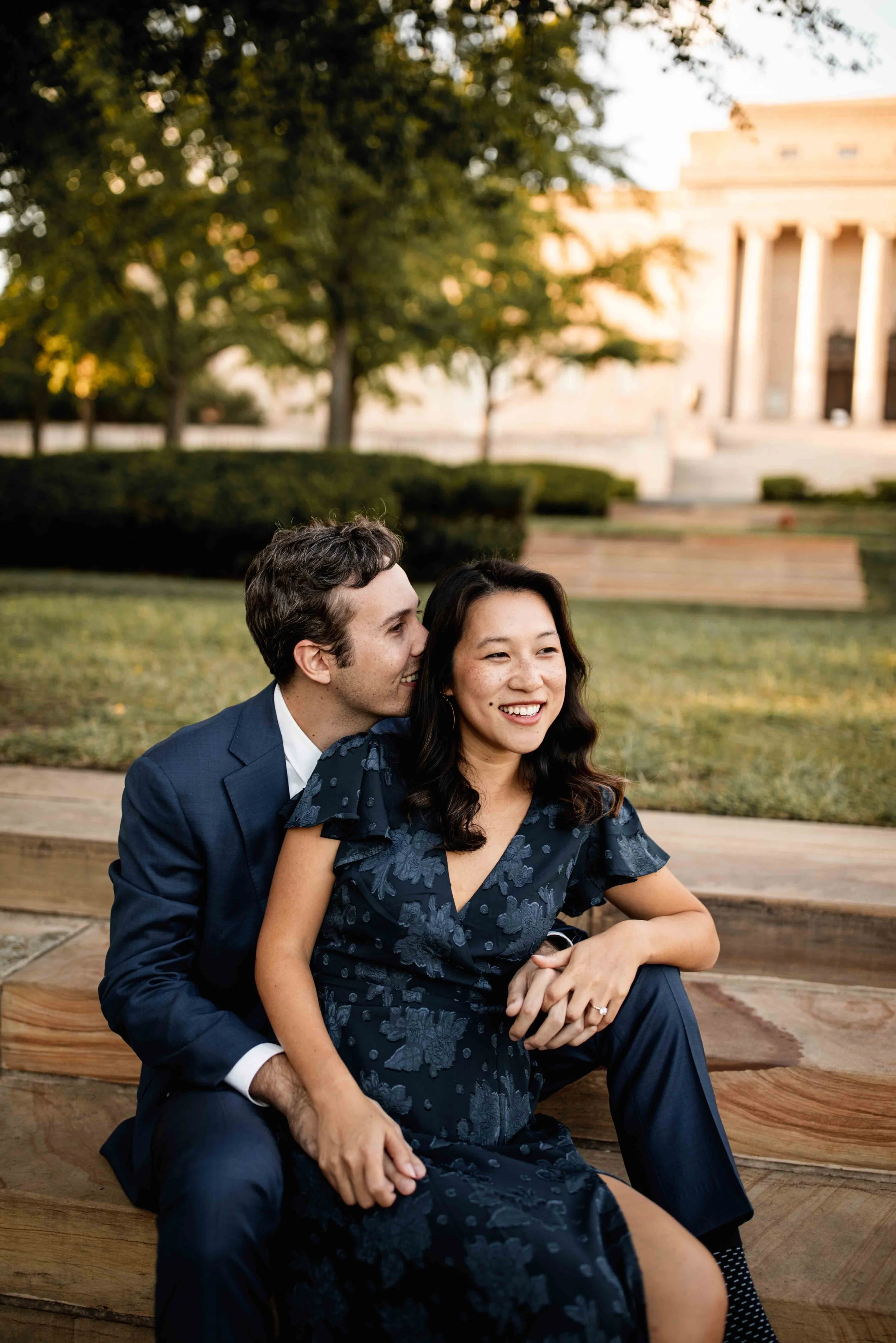 Happy couple sitting outside on Nelson Atkins lawn in Kansas City