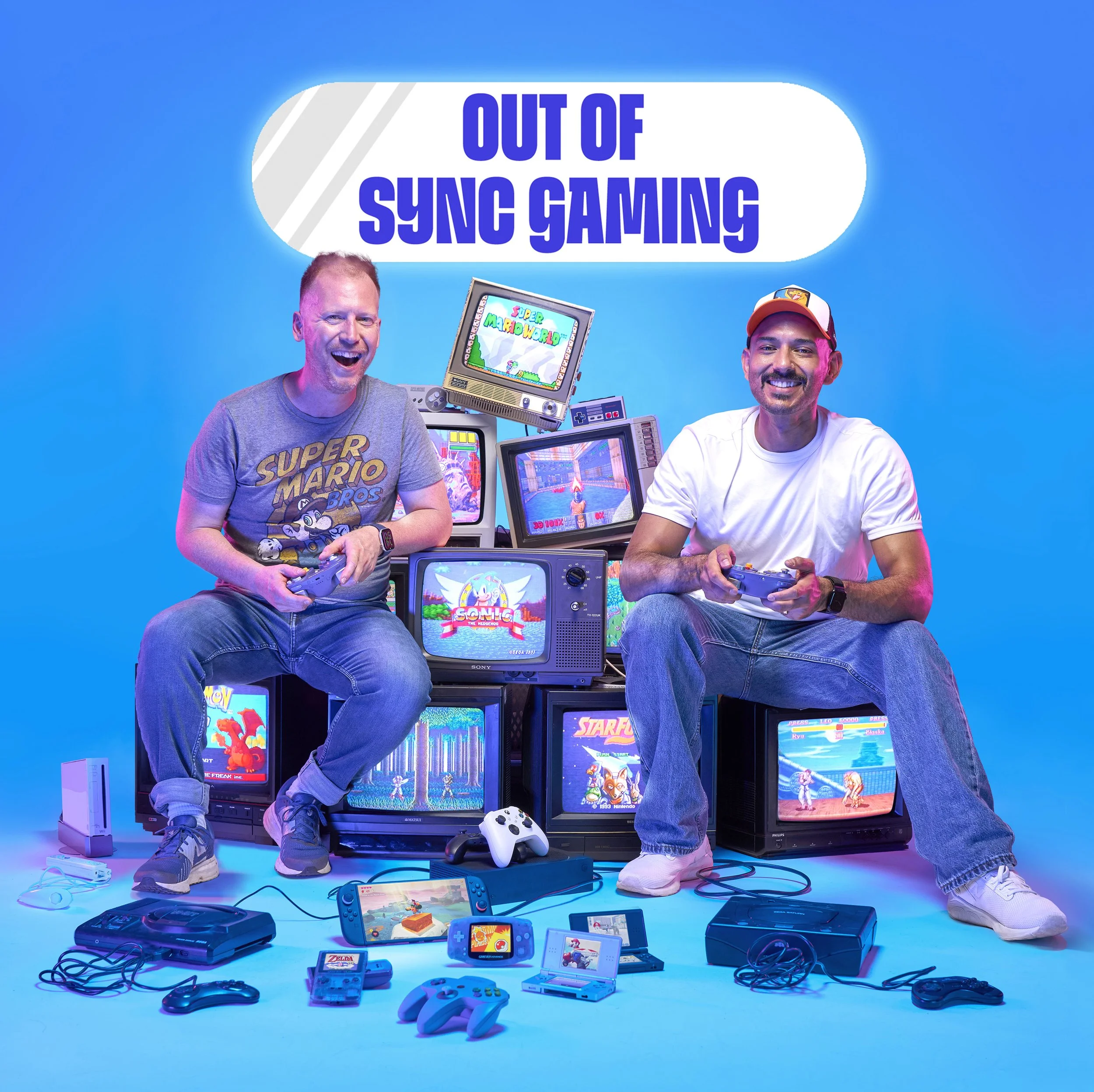 Cover image for the gaming podcast Out Of Sync. The two presenters sit on a stack of old CRT TVs, all showing classic computer games on the screens. They are holding games controllers and various consoles and controllers are scattered on the floor.