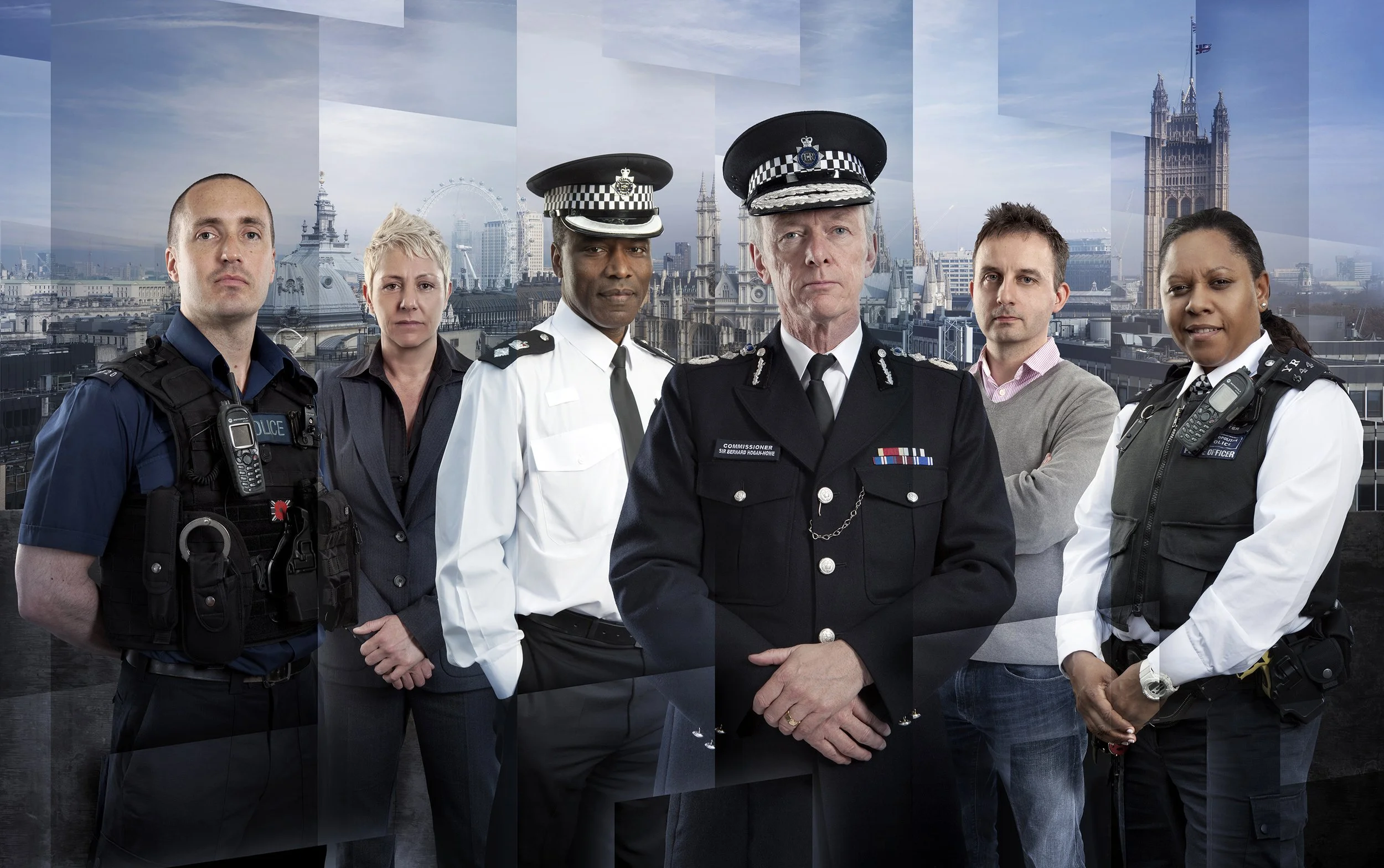 publicity image for the ITV documentary The Met. 6 police officers, representing different roles, stand in front of a London skyline. entertainment portrait photography by Steve Bright, London