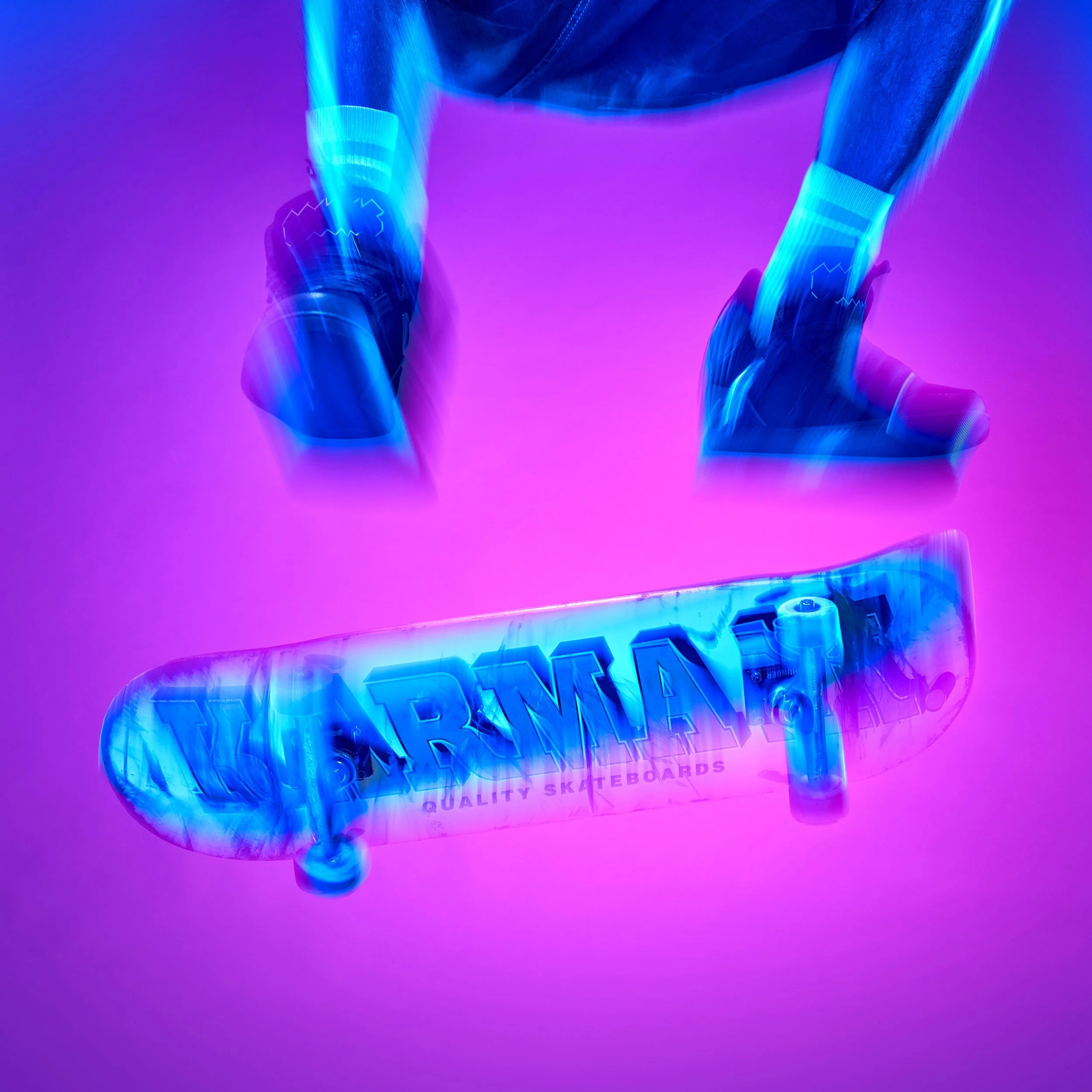 Closeup image of a skateboard in mid air as the skateboarder performs a heelflip. The board and his feet are partially motion blurred and partially frozen with flash. They are blue against a pink background