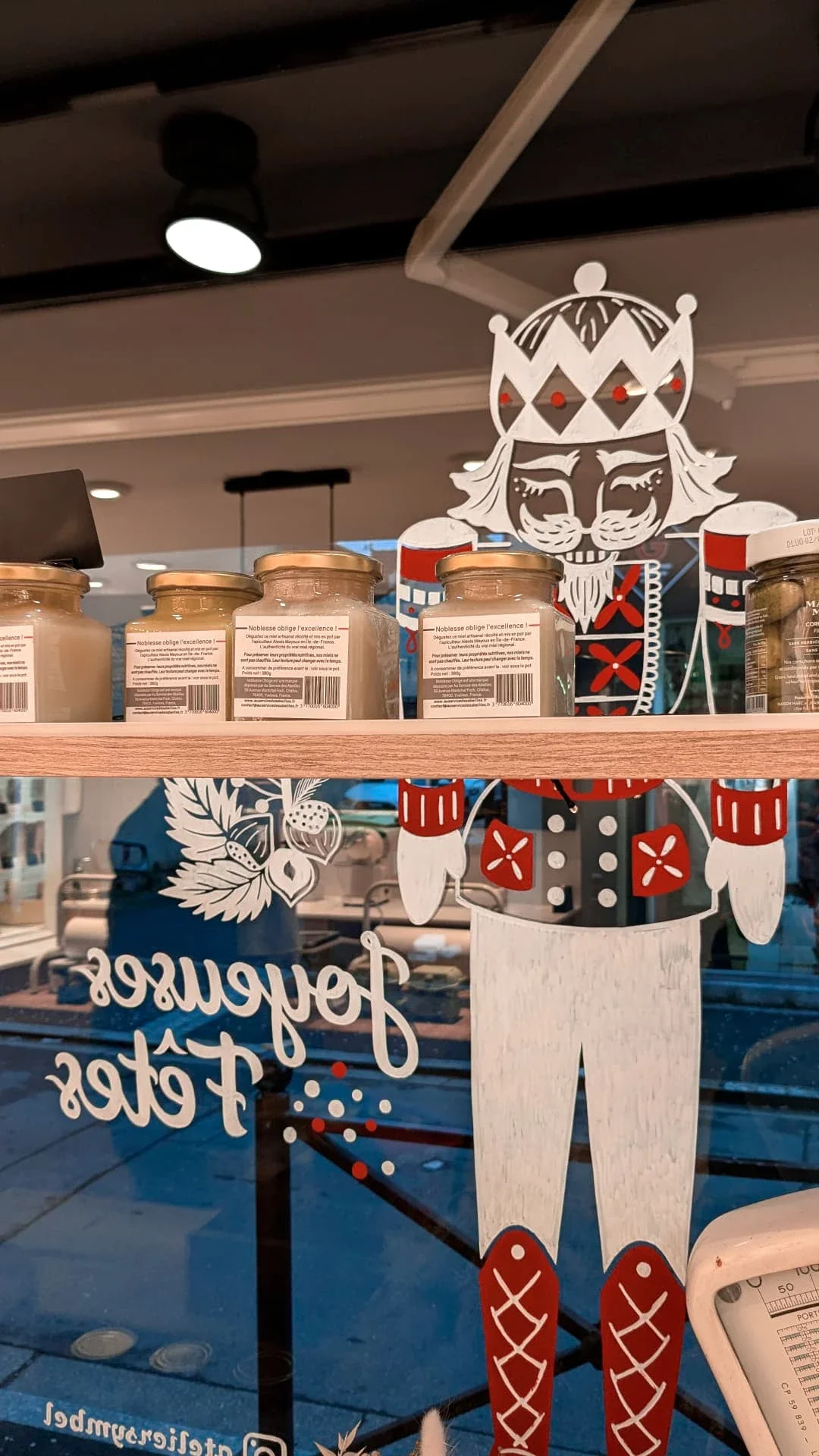 Peinture sur vitrine de Noël représentant un Casse-Noisette peint à la main pour la fromagerie Lallias à Houilles. Vue de la peinture sur vitrine depuis l'intérieur de la fromagerie
