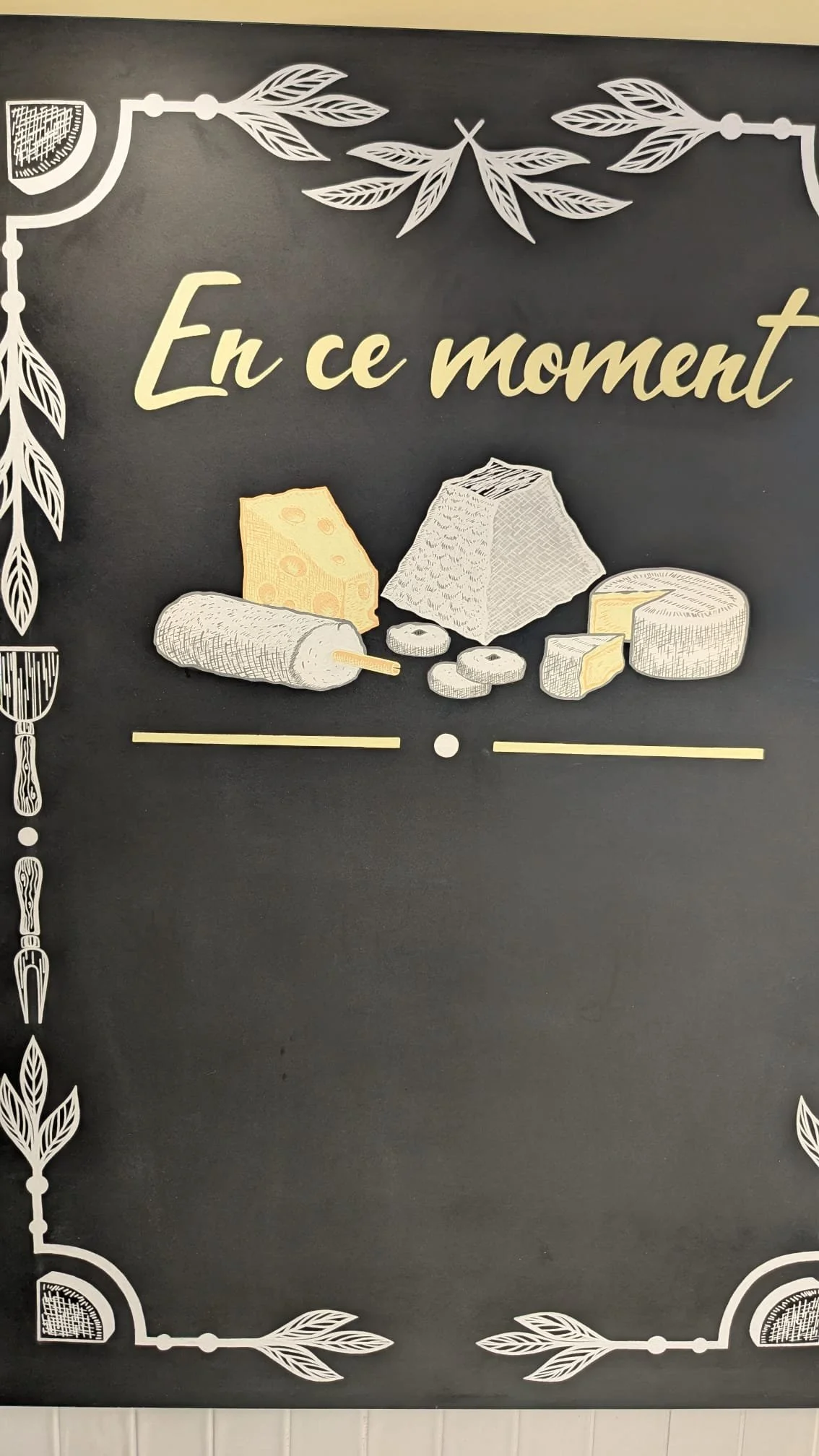Gros plan sur l'ardoise peinte à la main pour la fromagerie Lallias à Houilles (78). Décoration murale, frise d'encadrement, fromages