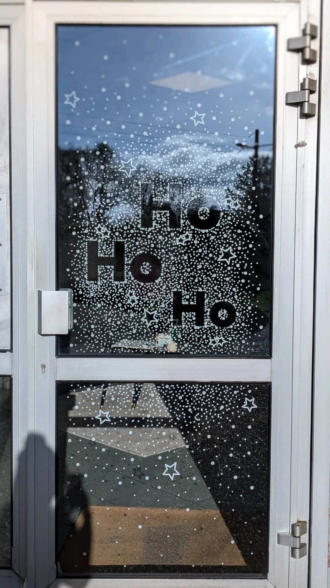 Lettrage « Ho Ho Ho » peint à la main sur la porte de l'accueil de l'entreprise Vygon à Ivry-le-Temple