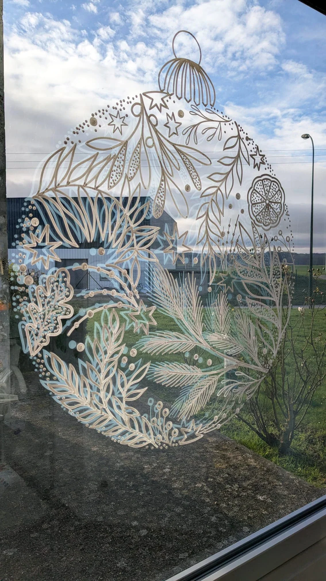 Boule de Noël peinte sur la fenêtre de l'accueil du groupe Vygon avec les reflets de la vitre - Ivry-le-Temple