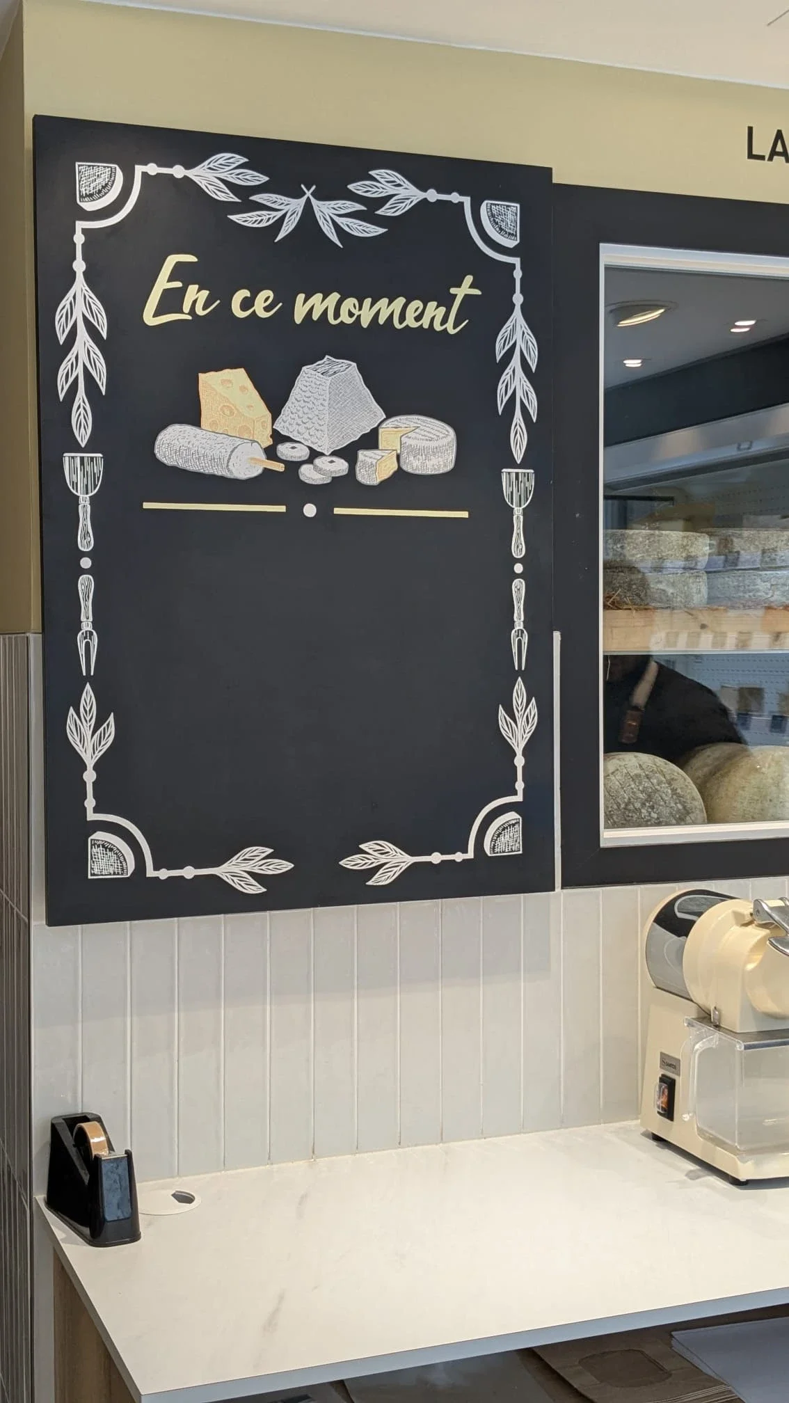 Ardoise murale peinte à la main pour une fromagerie à Houilles (Yvelines 78) – illustration de fromages, couteaux et frise décorative végétale