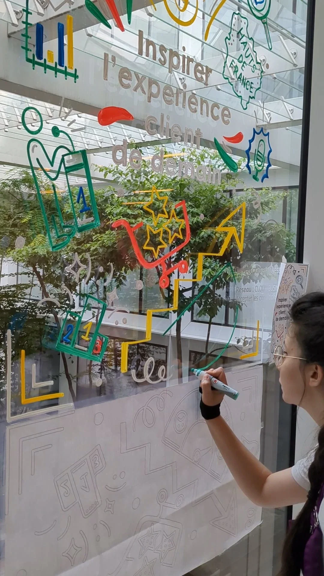 Sandrine Daniel réalise le visuel « Inspirer l'expérience client de demain » avec illustrations et lettrage peints à la main sur vitrine