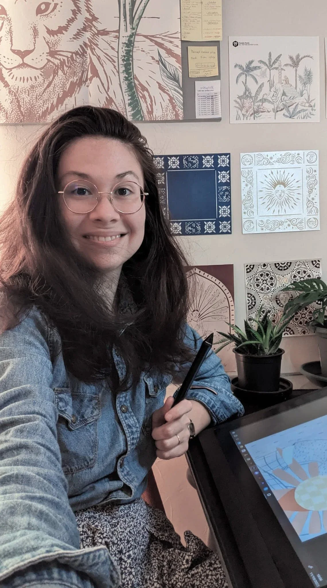Sandrine Daniel, illustratrice et peintre de vitrines, dans son atelier devant sa tablette graphique avec ses illustrations au mur — Atelier Symbel
