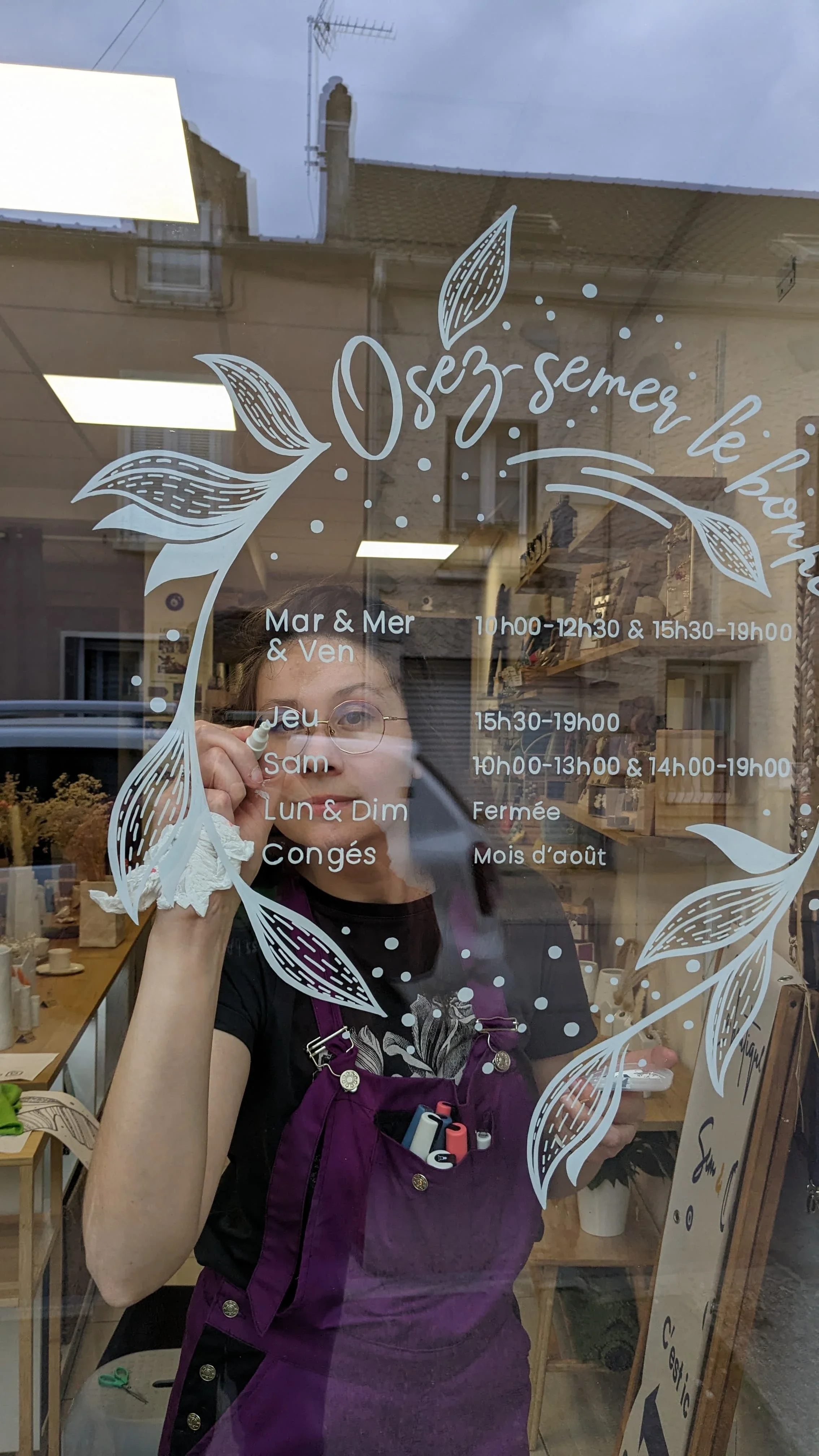 Peinture sur vitrine. Lettrage blanc peint à la main pour la couronne d'horaires d'une boutique de décoration à Houilles (78)