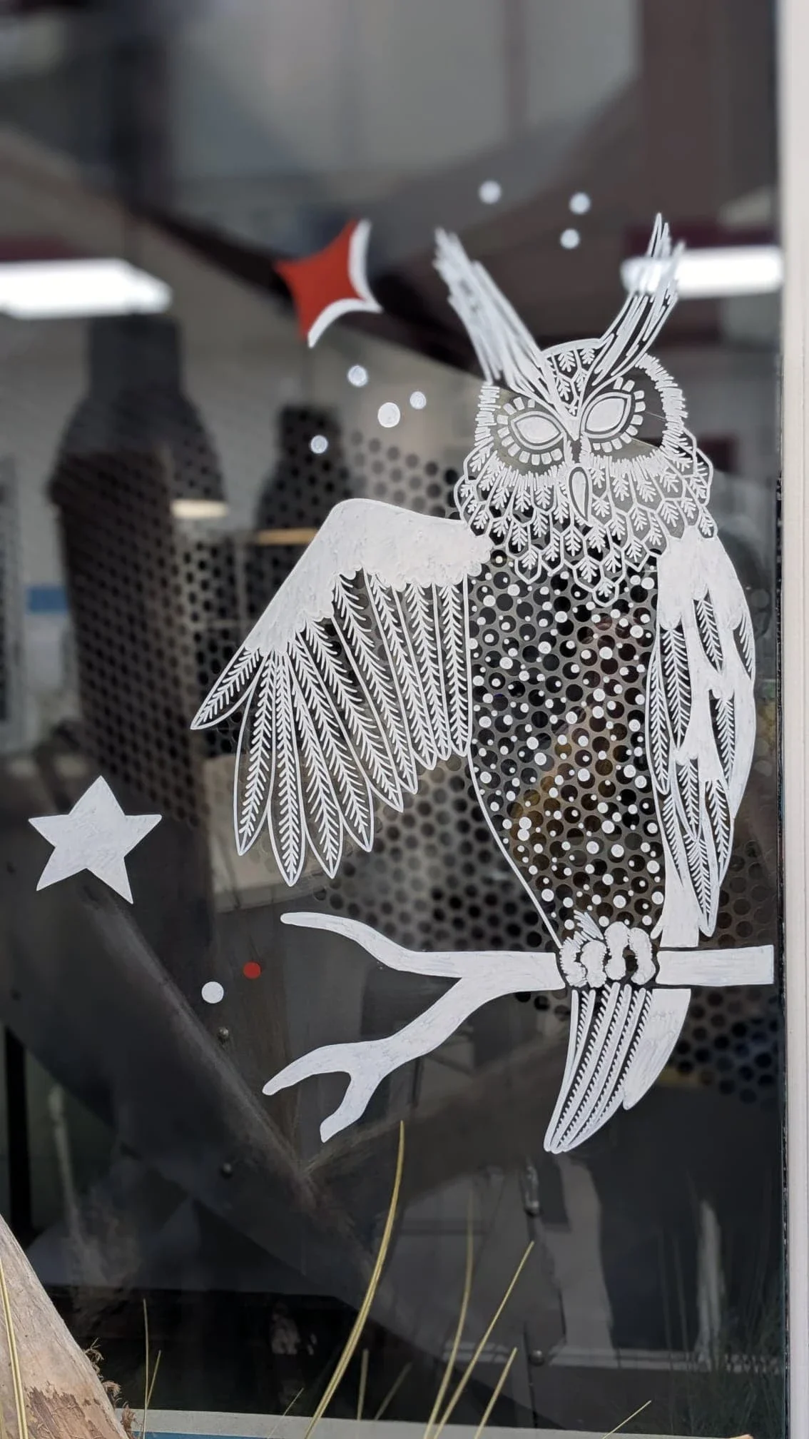 Hiboux perchés sur une branche entourée d'étoiles, peints à la main sur la vitrine du réfectoire du groupe Vygon à Ivry-le-Temple