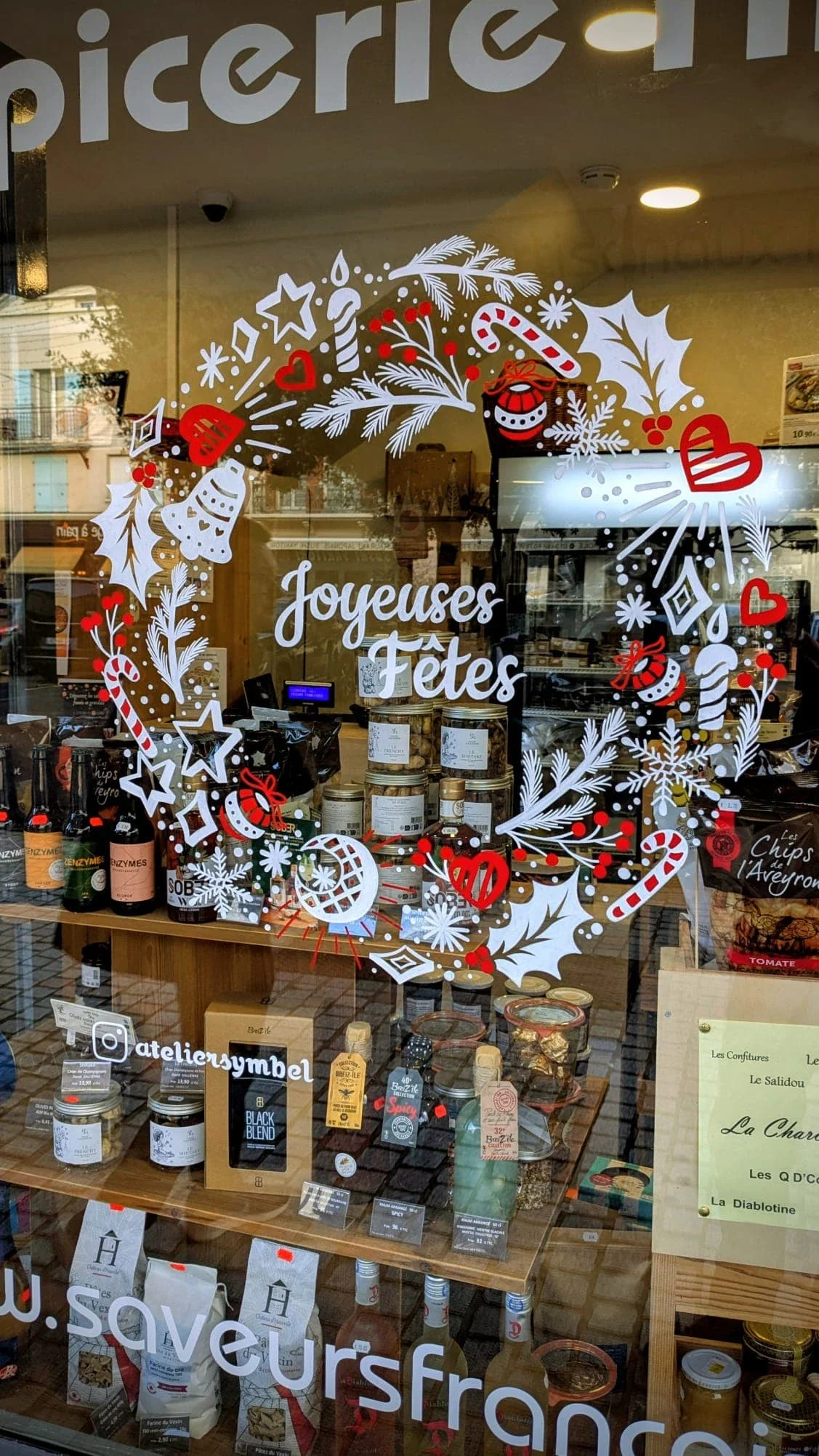 Détail de la couronne Doodle peinte à la main montrant sucre d'orge, flocons, baies, feuillages et motifs végétaux sur une vitrine de Noël à Vauréal (95)
