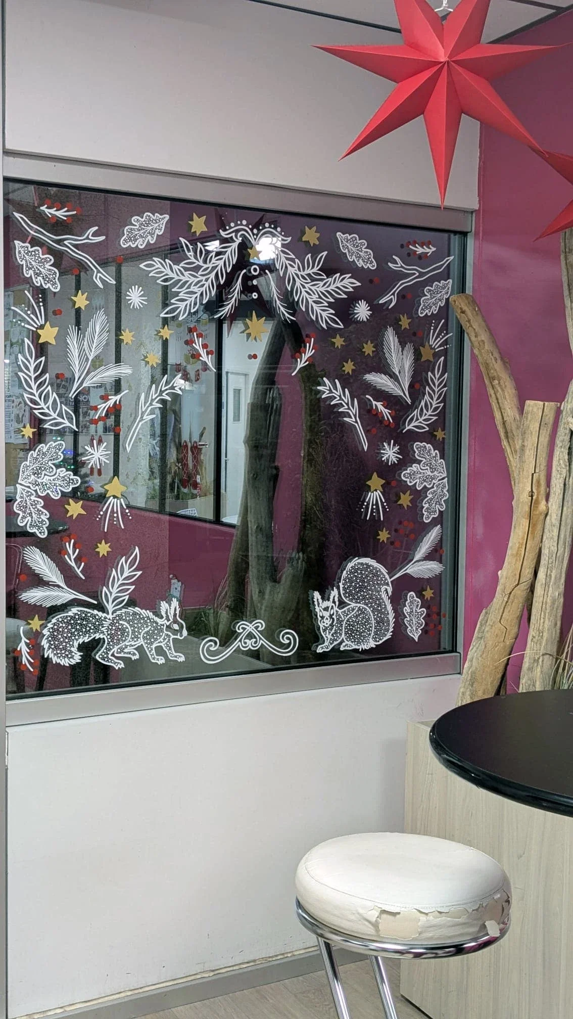 Décoration de Noël peinte à la main sur la fenêtre de l'espace café avec motifs végétaux et écureuil pour le groupe Vygon à Ivry-le-Temple