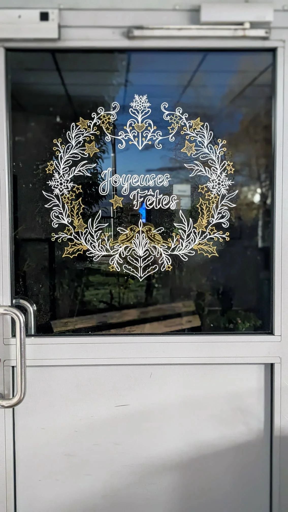 Couronne de Noël peinte à la main sur la porte de l'espace café du groupe Vygon, blanc et doré