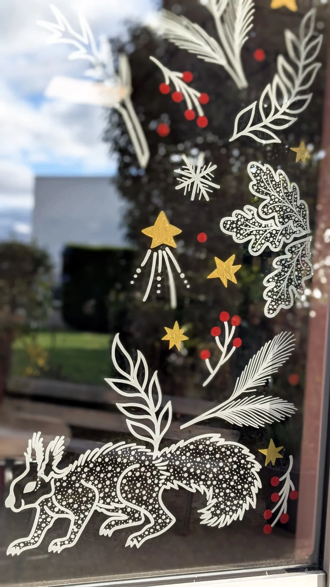 Peinture sur vitrine Noël - décoration entreprise - Espace café - porte - couronne de Noël - fenêtre motif végétaux et écureuil - détail - Groupe Vygon site Ivry-le-Temple