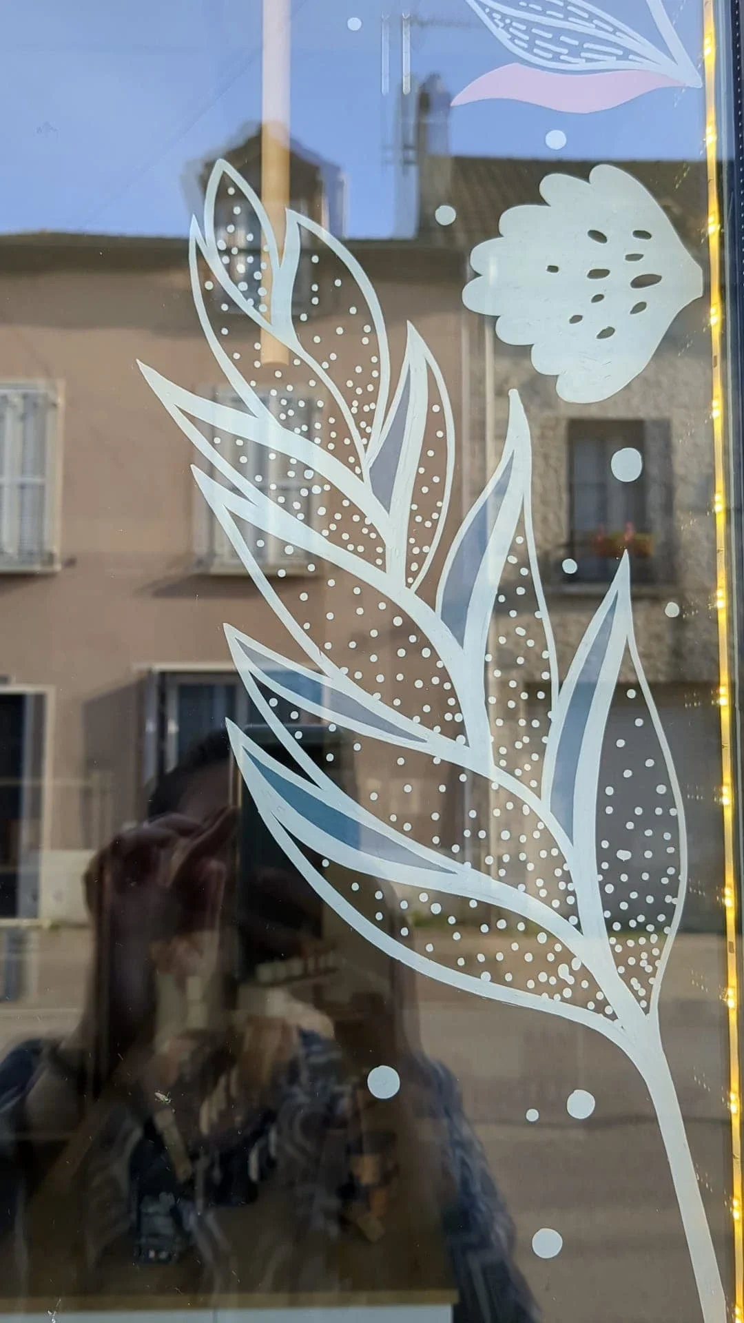 Peinture sur vitrine. Gros plan sur des végétaux de la frise.