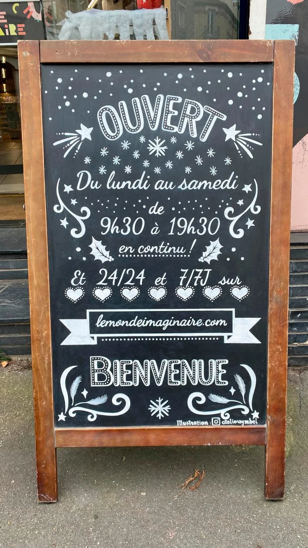 Ardoise peinte à la main pour une boutique de jouets à Houilles (78) - Message de bienvenue et informations sur les horaires d'ouverture , site internet. Lettrages peint. Coloris blanc