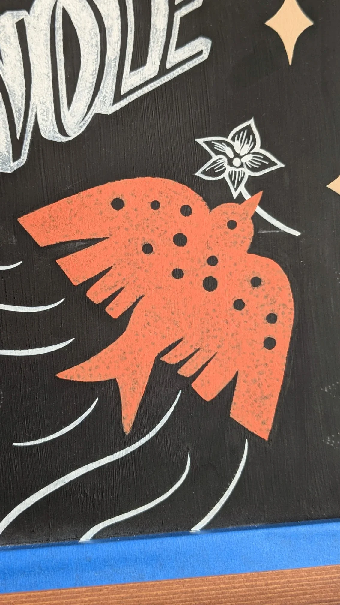 Détail d'un oiseau peint à la main avec un effet de texture obtenu par tamponnage sur une ardoise décorative