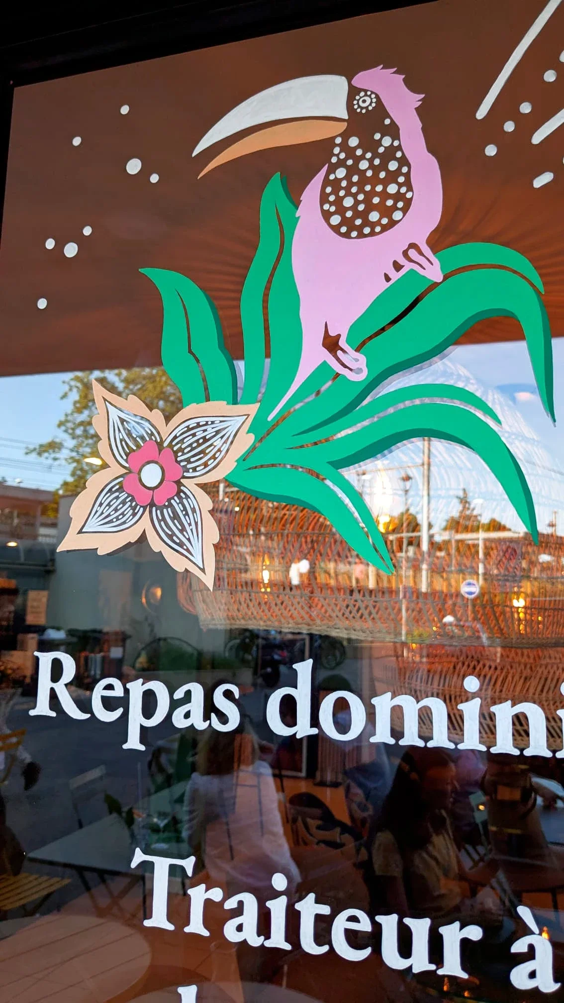 Vitrine peinte à la main pour un bistrot à Chatou (Yvelines 78) – illustration jungle colorée avec toucan, fleur stylisée et lettrage blanc "repas dominical" et "traiteur à domicile"