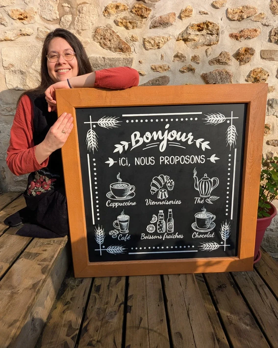 Illustration et peinture sur une ardoise murale pour la boulangerie Duhamel à Saint-Germain-en-Laye (78) - peinture terminée, l'illustratrice Sandrine Daniel pose à côté de l'ardoise - Yvelines- Atelier Symbel