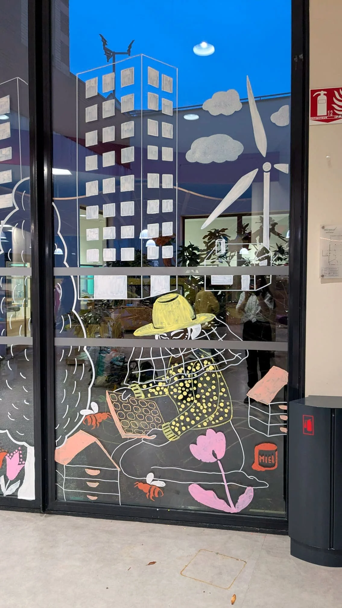 Fresque participative sur les vitrines du patio de la médiathèque des Mureaux, réalisée lors des Nuits de la lecture 2026. Thème "Villes et campagnes" — Panneau droit