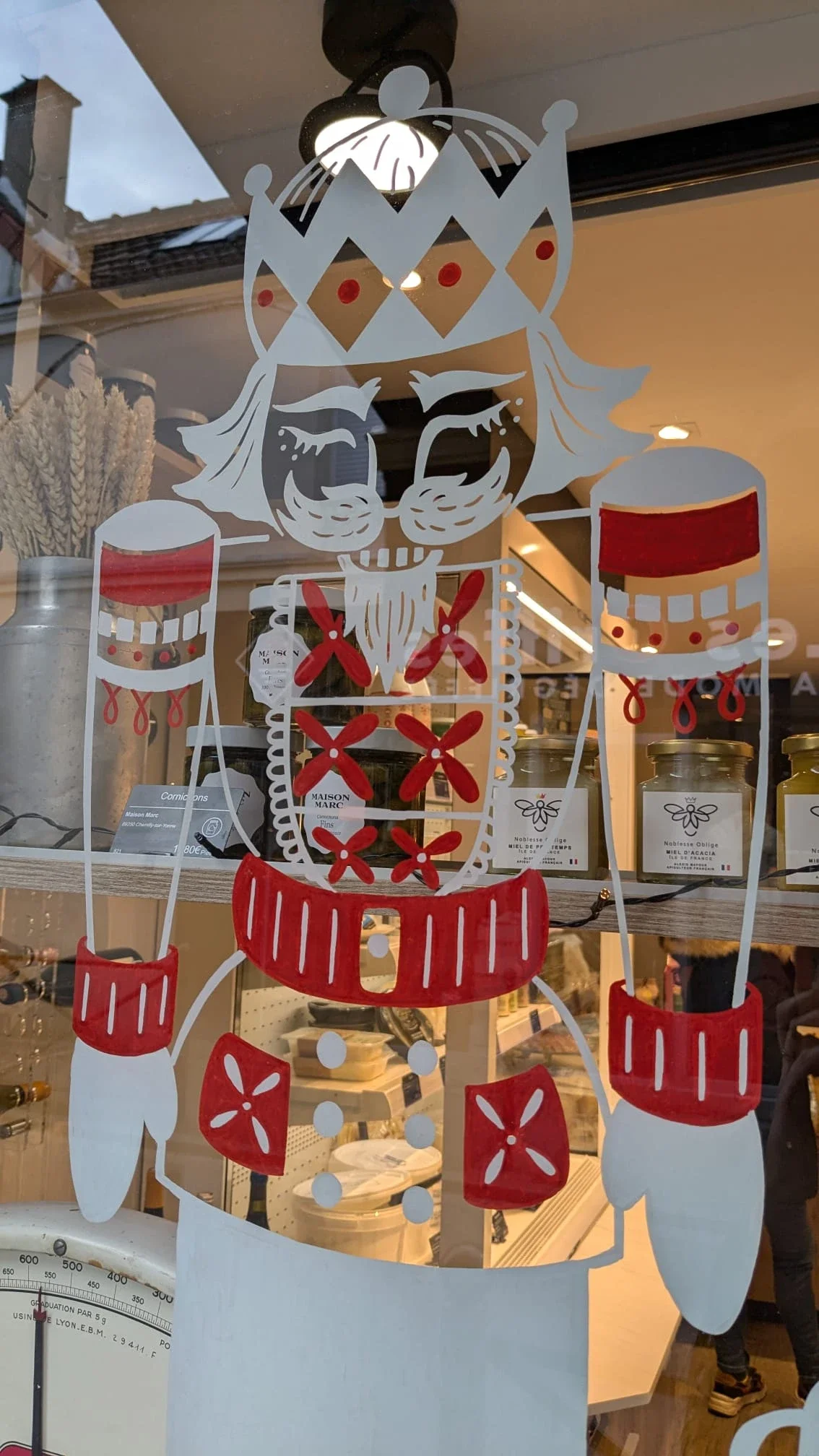 Gros plan sur le motif Casse-Noisette peint à la main pour la décoration de Noël de la vitrine de la fromagerie Lallias à Houilles