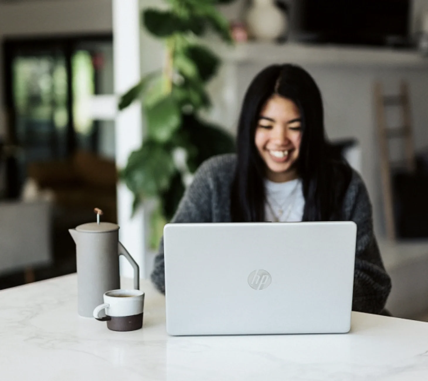 a young woman sitting at her laptop in an online therapy sessions