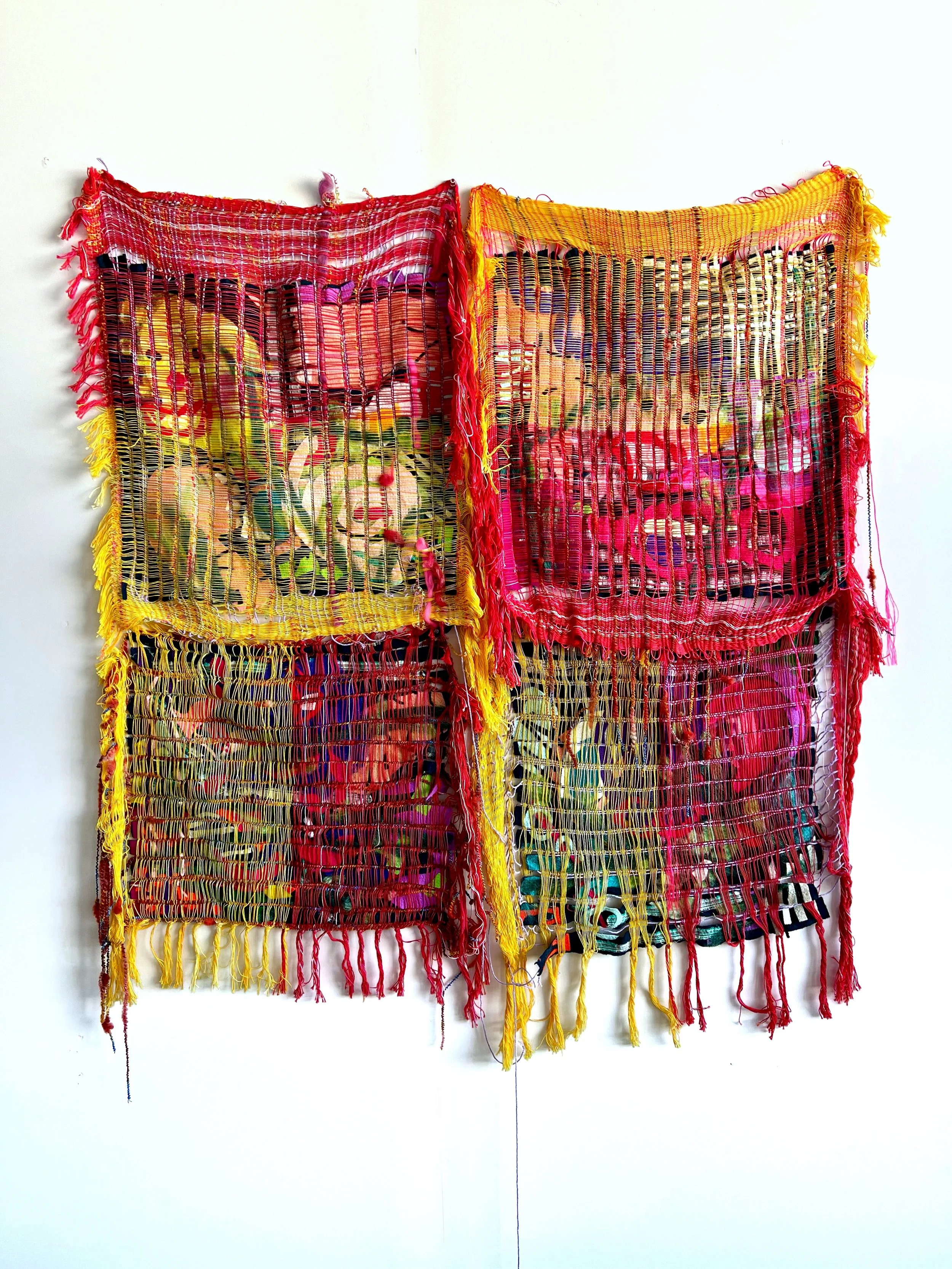 Colorful textile wall hanging made of woven fabric with bright red, yellow, pink, green, and black colors, displaying a patchwork of woven squares with fringed edges.