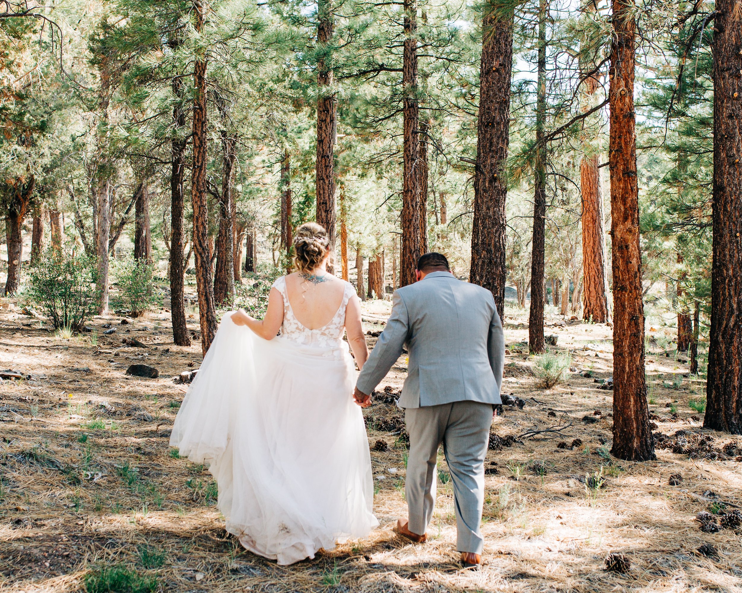 bride and groom walking into forest.jpg