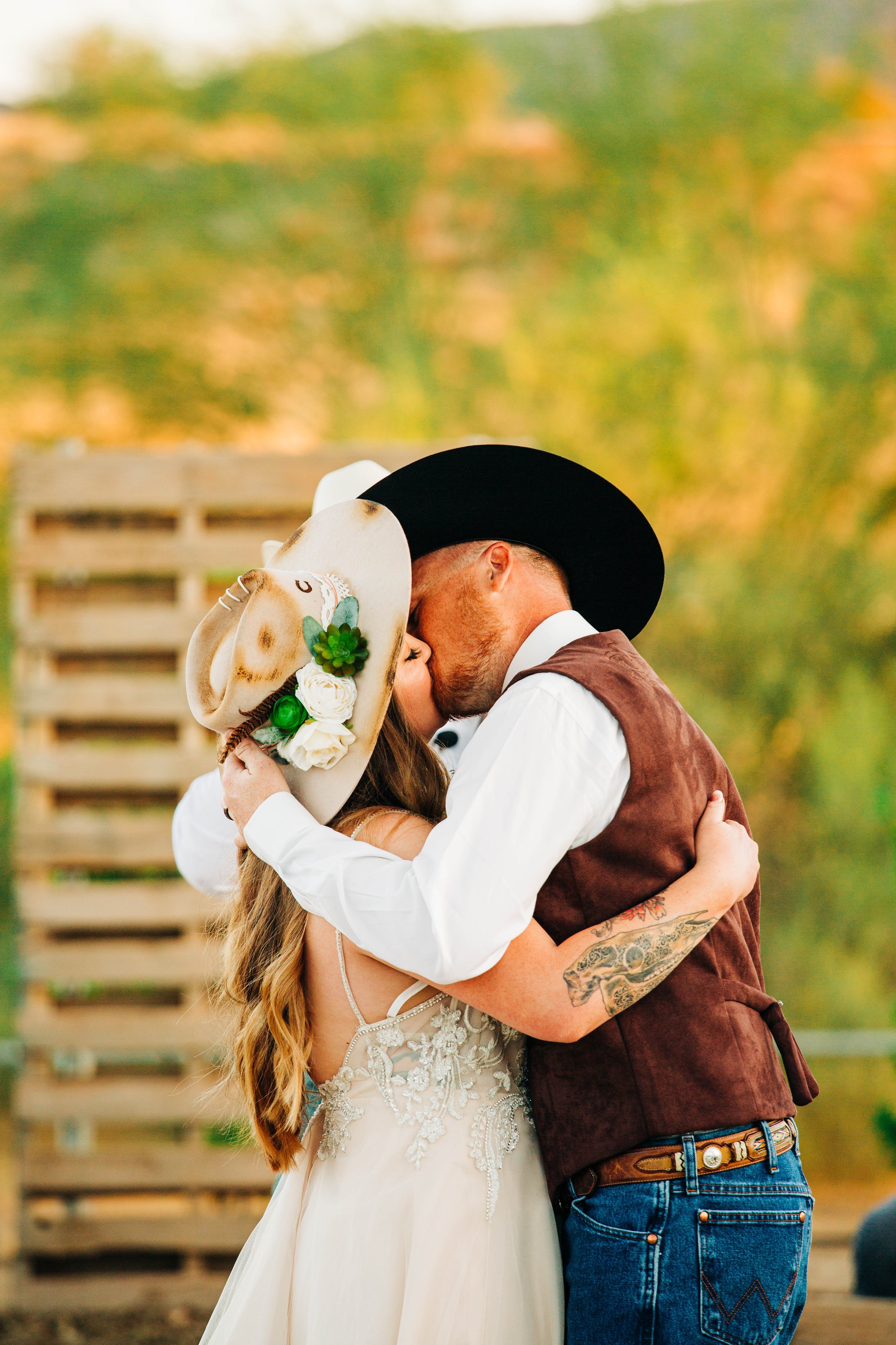 bride and groom kissing cowboy hats.jpg