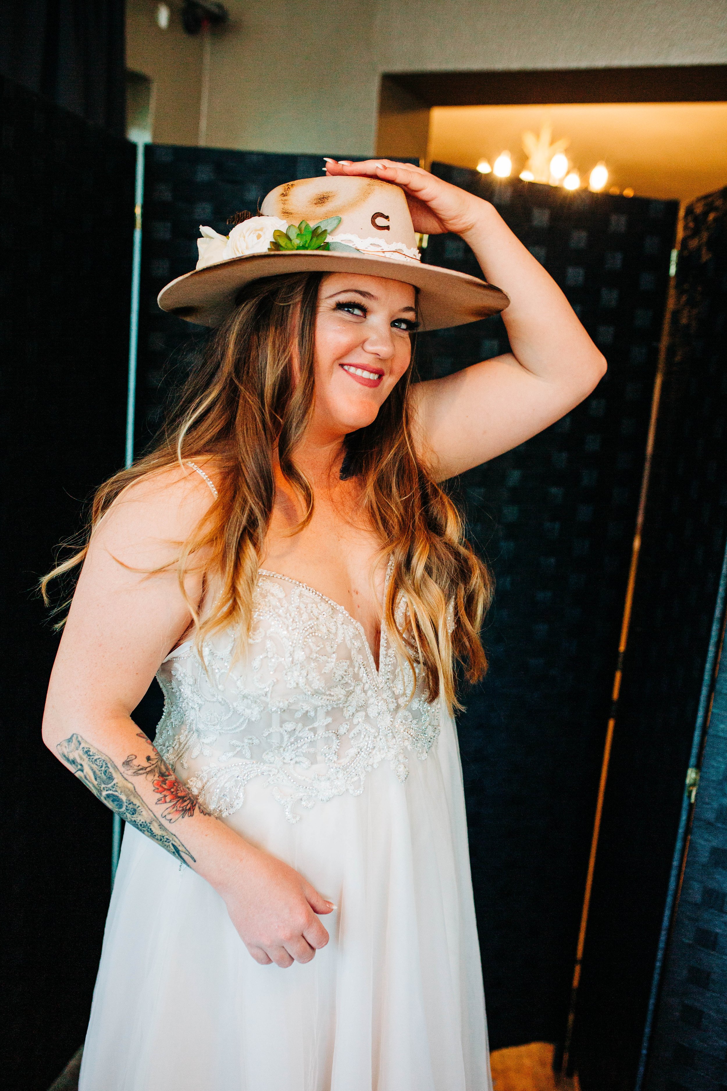 bride putting on wedding cowboy hat.jpg
