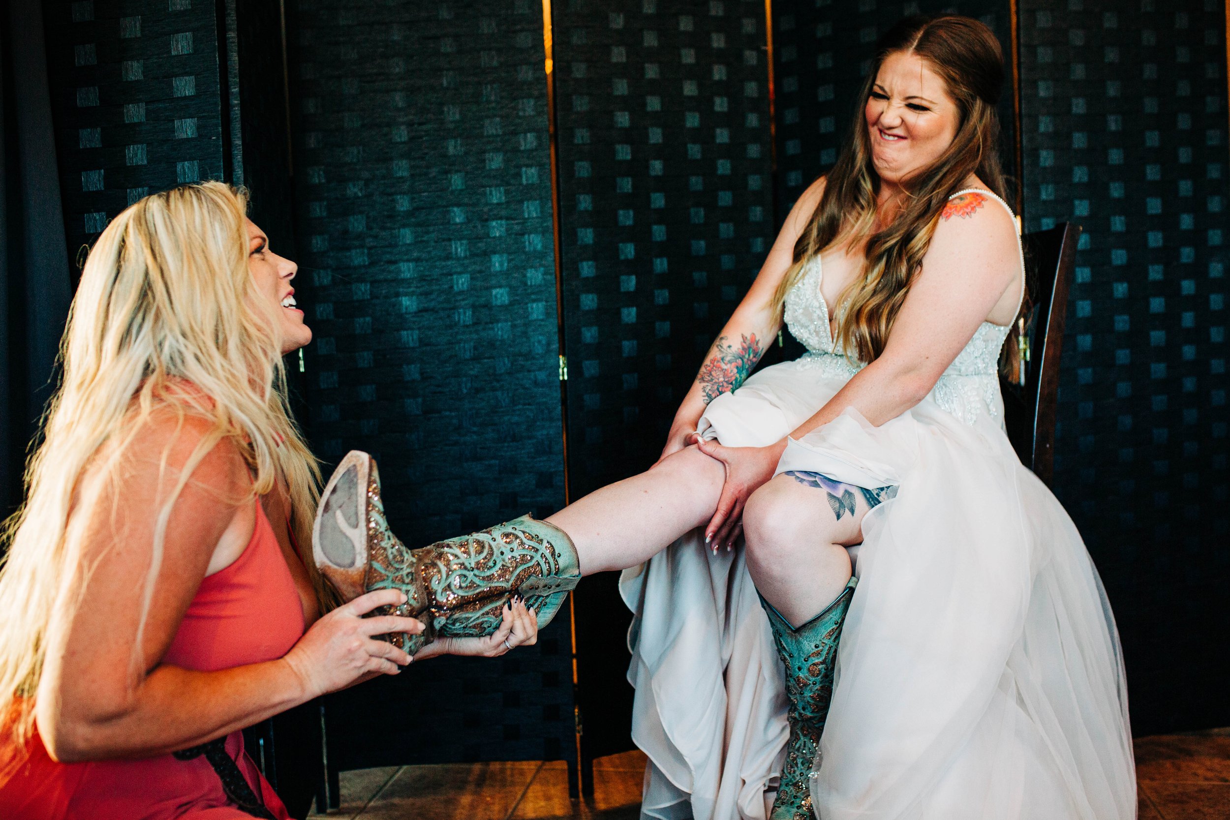 maid of honor putting shoes on bride.jpg